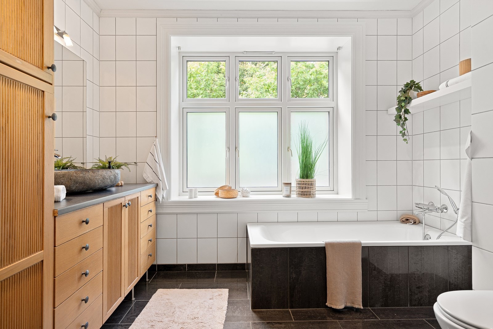 Her får du ett stort og lyst flislagt bad, med et herlig badekar å kunne slappe av i etter en hektisk dag. Galleribilde