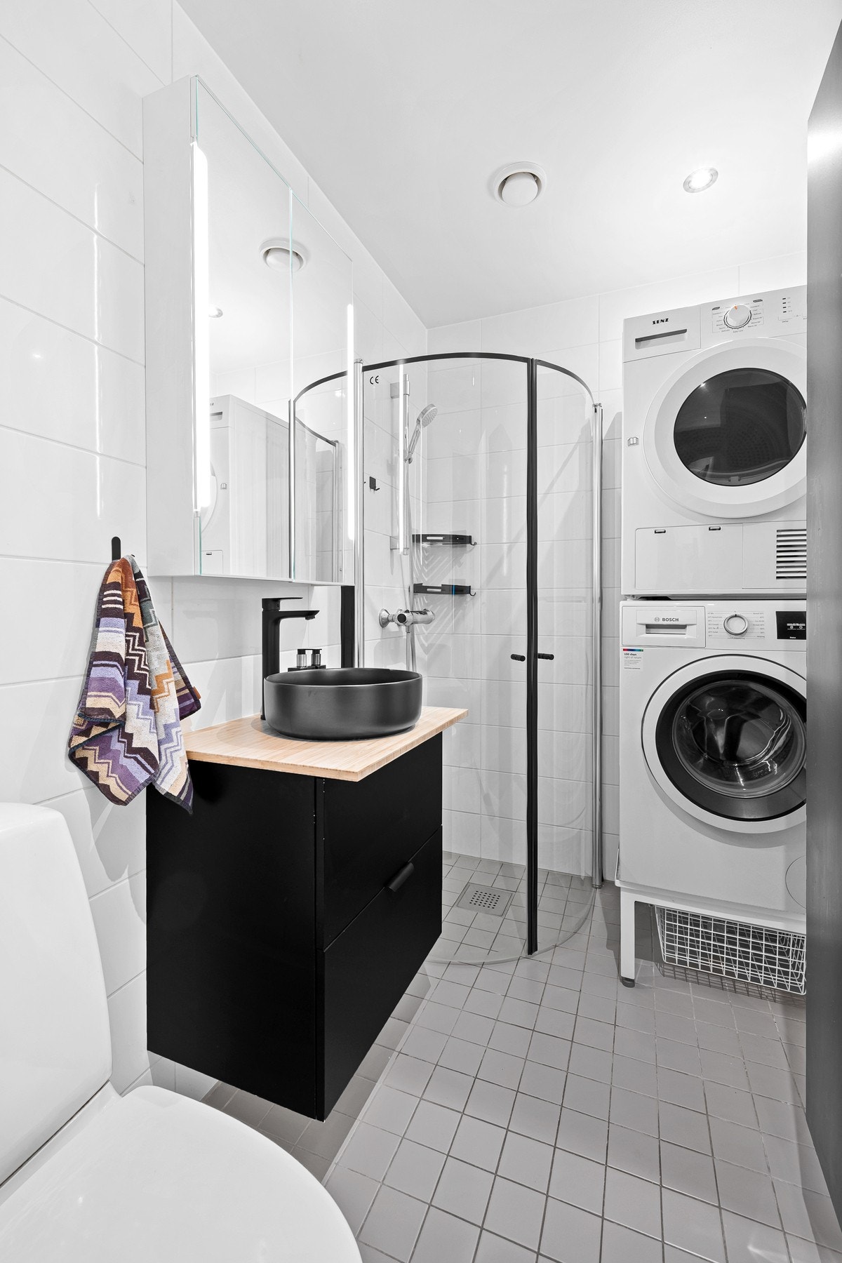 Badet har fliser på gulv og vegger. Gulvvarme sørger for behagelig temperatur, og det er god drenering mot sluket. Galleribilde