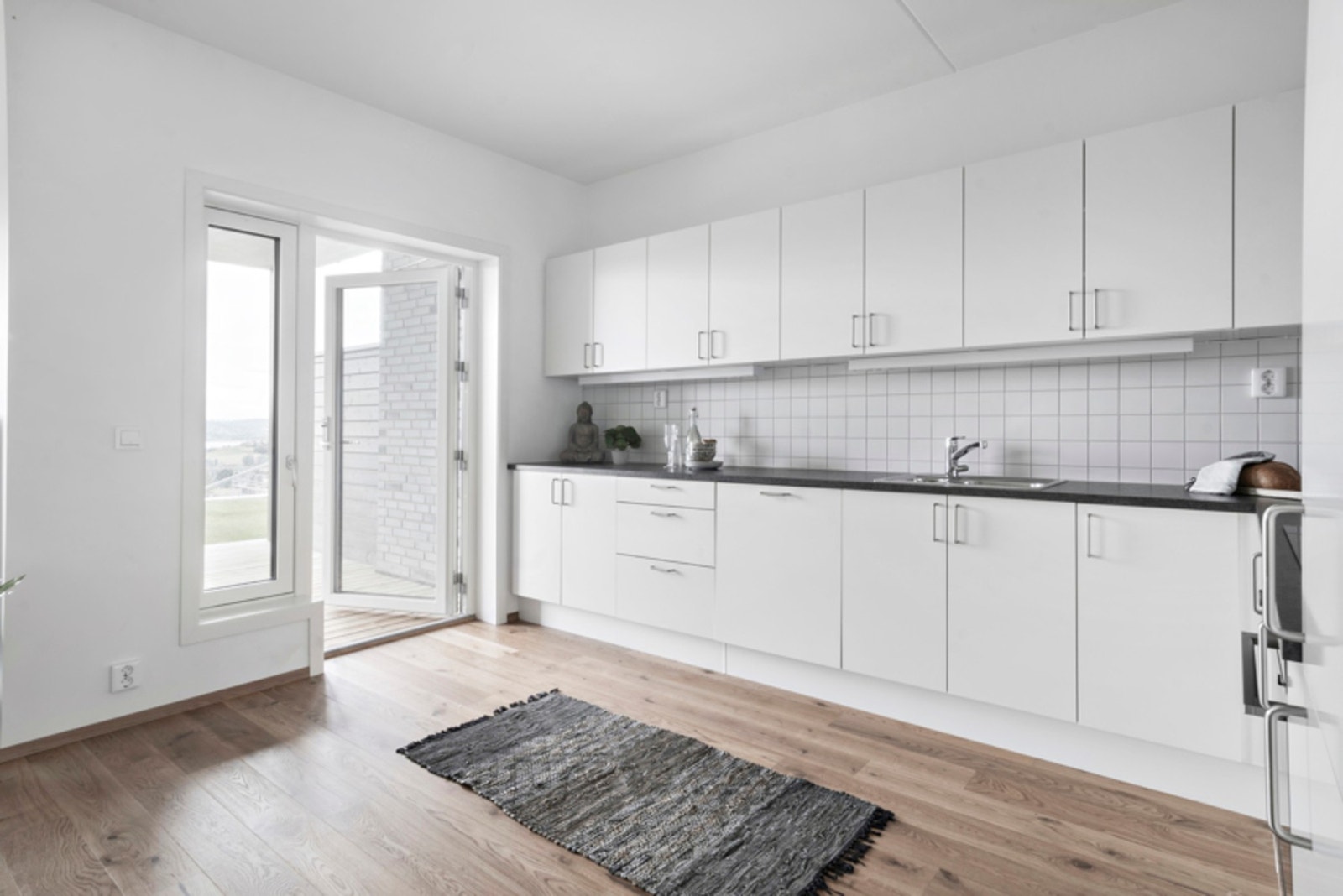 Kjøkken med mye skapplass og utgang til markterrasse Galleribilde