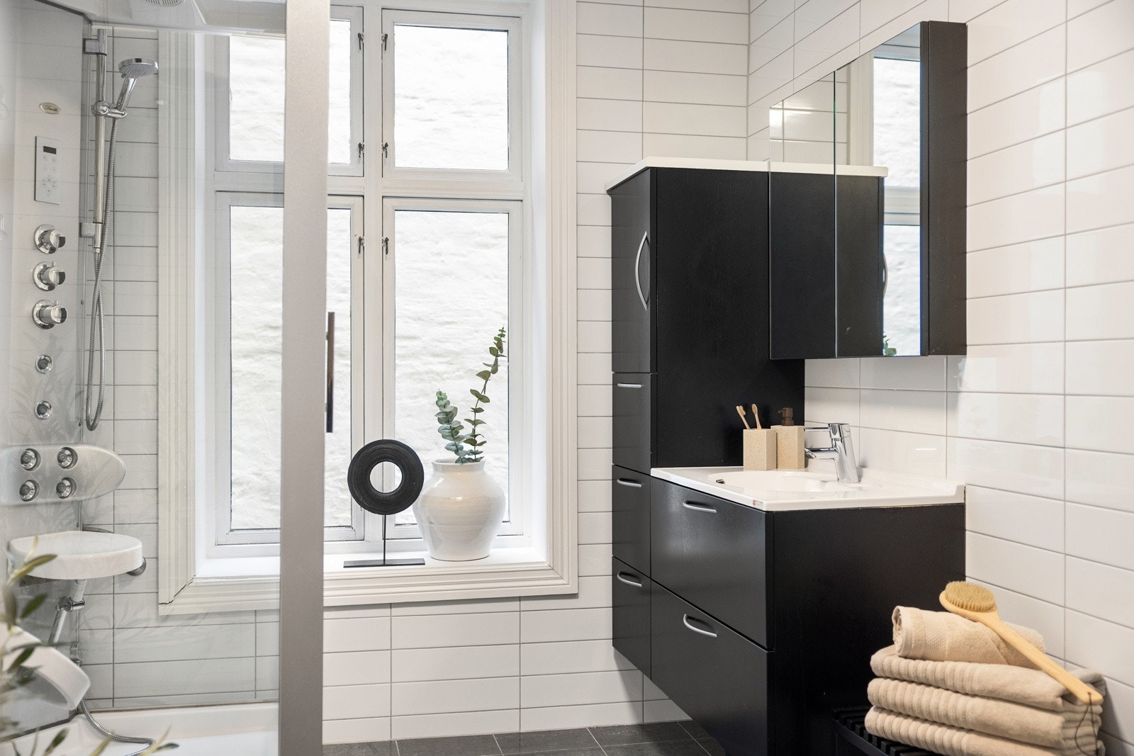 Baderomsinnredning med heldekkende servant, servantskuffer, skap og speilskap. Galleribilde