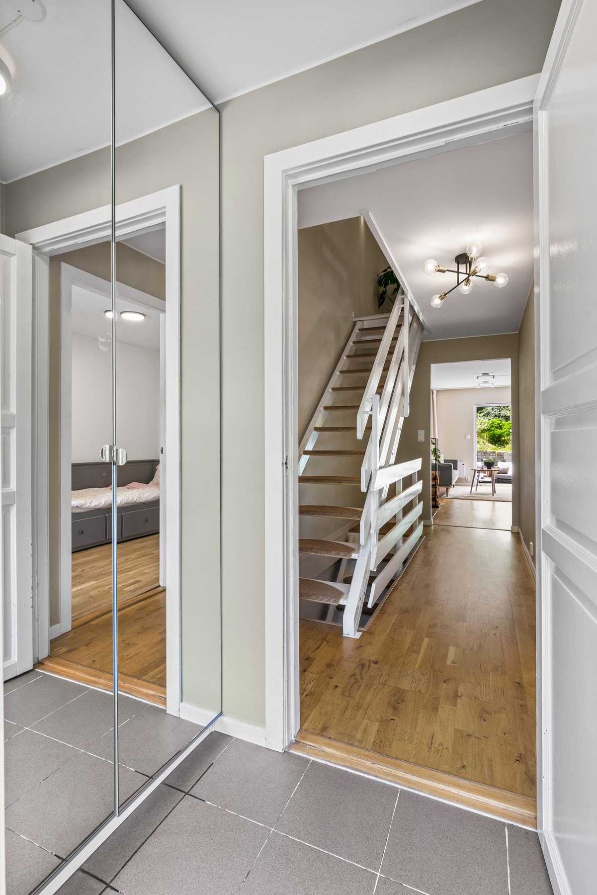 Lys entré med garderobeskap med store speilfronter til yttertøy og sko. Galleribilde