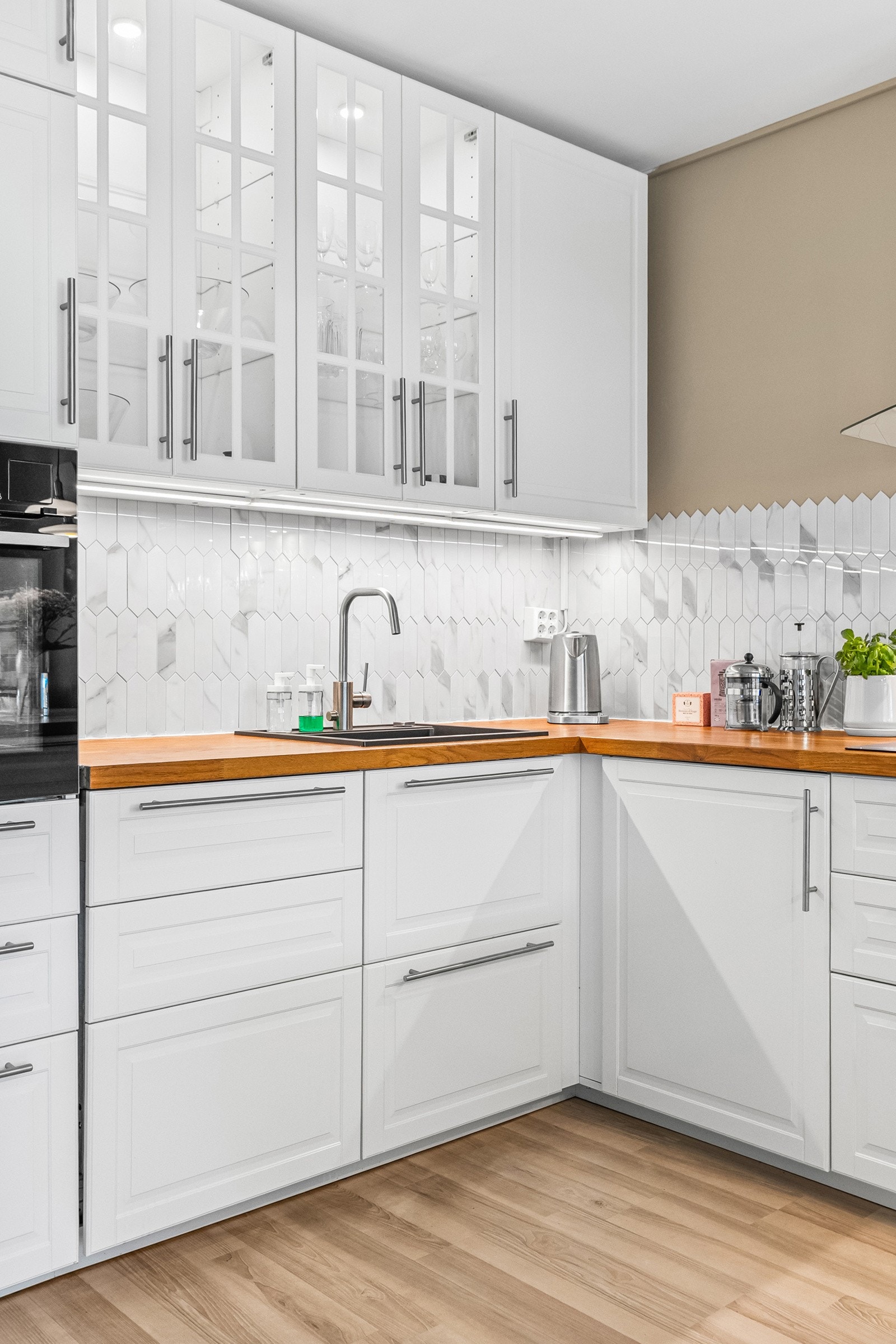 Både fint og praktisk med klistremerke-fliser i benkeryggen og belysning under overskapene. Galleribilde