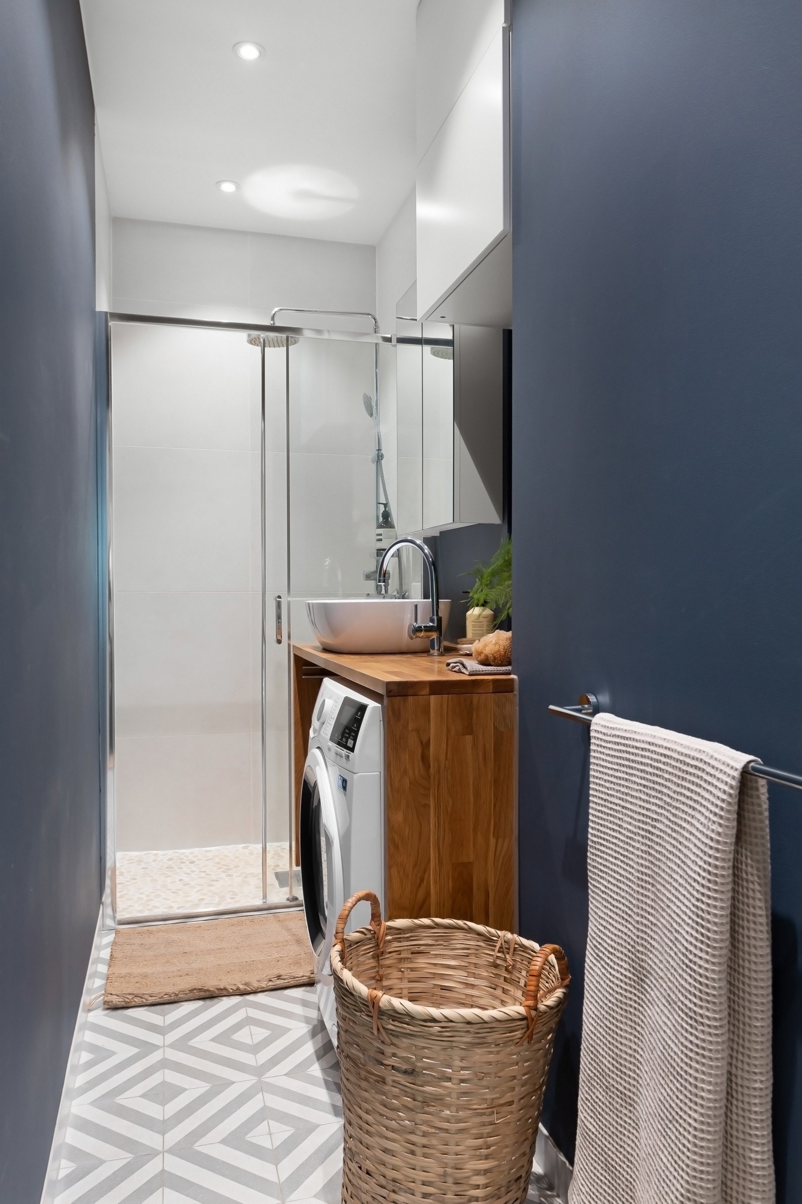 Leiligheten har et moderne bad som ble etablert i 2018/2019, samt et separat toalettrom. Badet er utført med lyse mønsterfliser på gulvet, rullesteiner på gulvet i dusjen, kombinert med lyse mosaikkfliser og storformatfliser på veggene i dusjsonen. Galleribilde