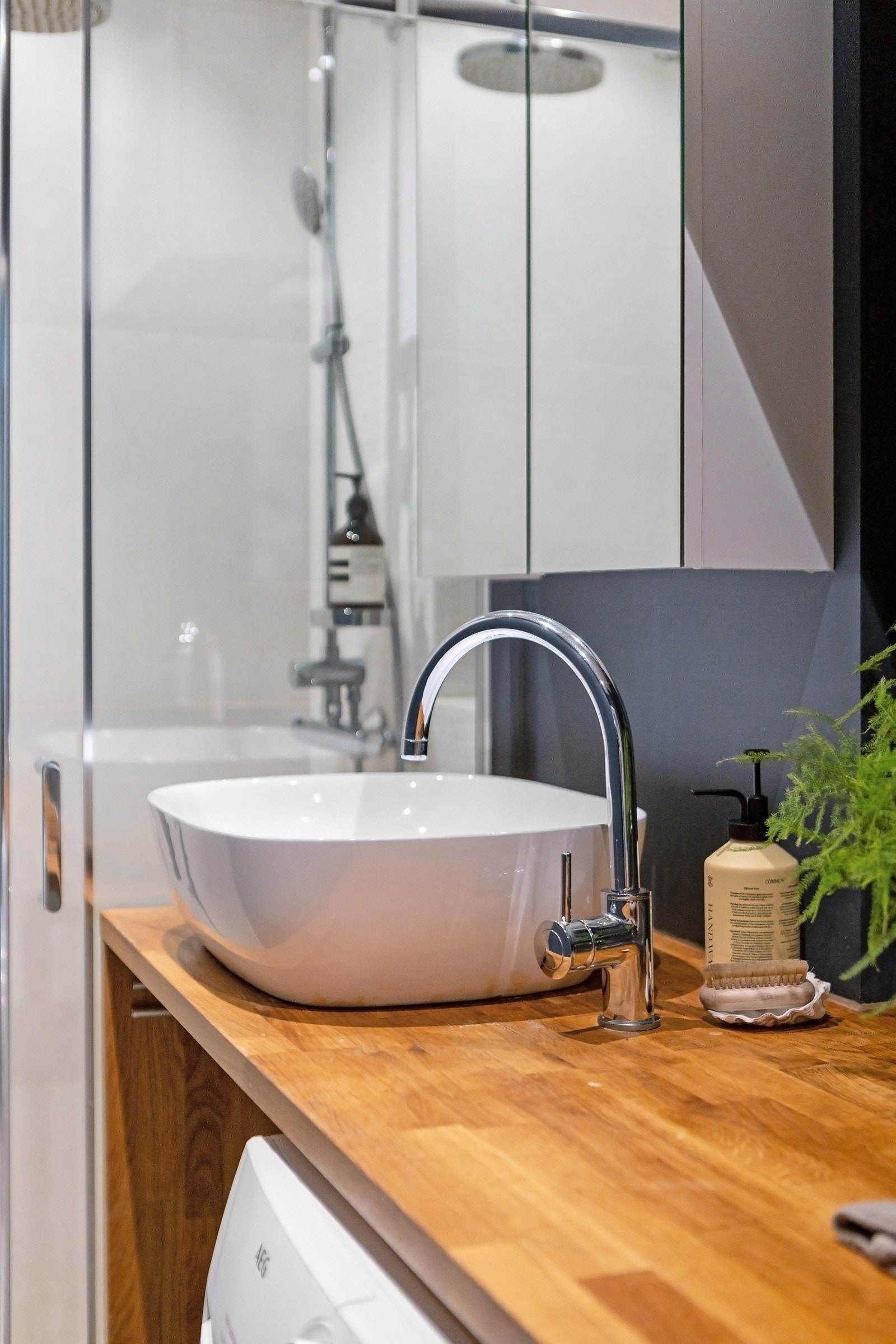 Innredningen består av en bolleservant på servantbenk i heltre, et speilskap og et hvitt veggskap. Galleribilde