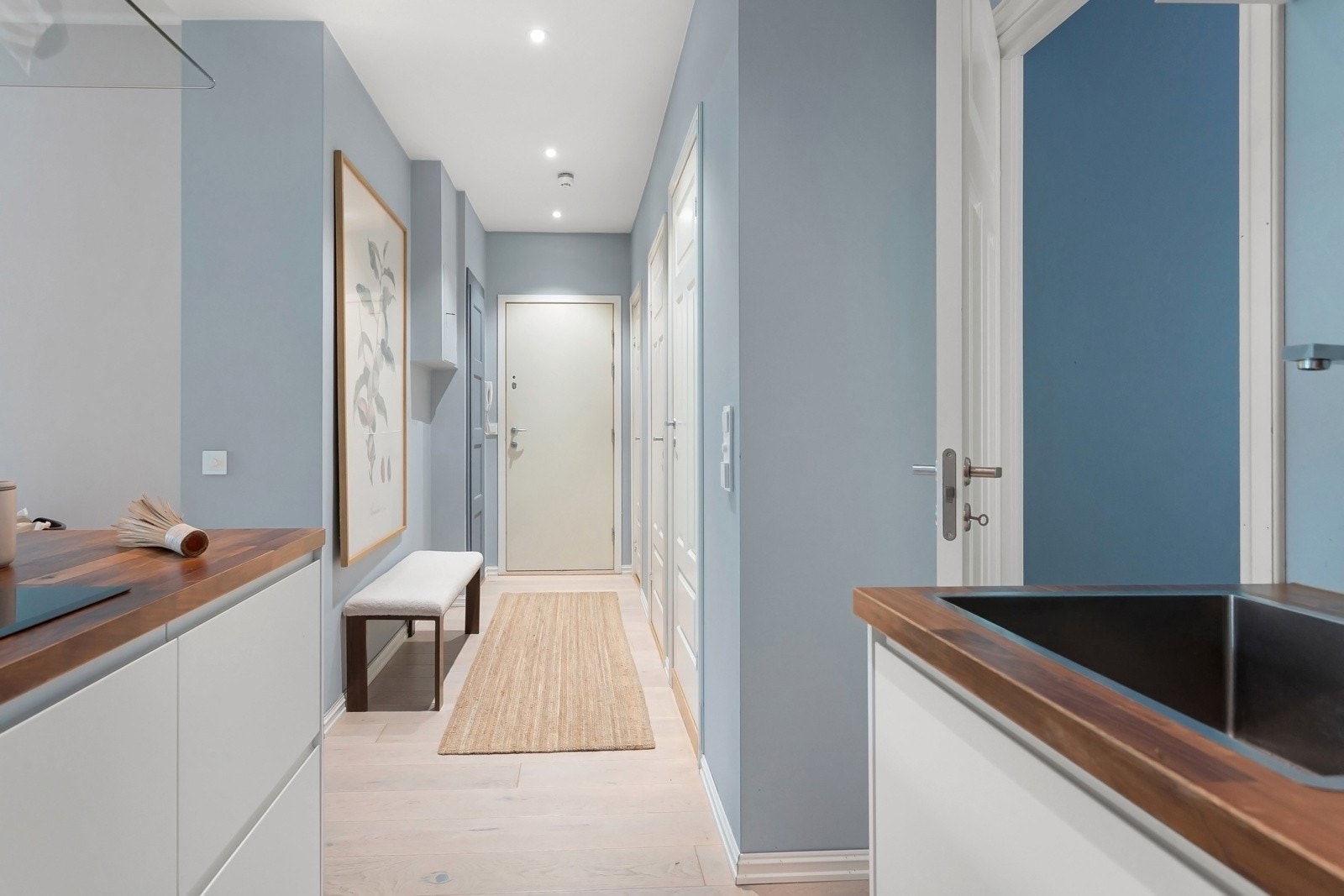 Entréen har downlights i himlingen, dørcalling ved ytterdøren og et originalt, plassbygd garderobeskap med blåmalt dør. Galleribilde