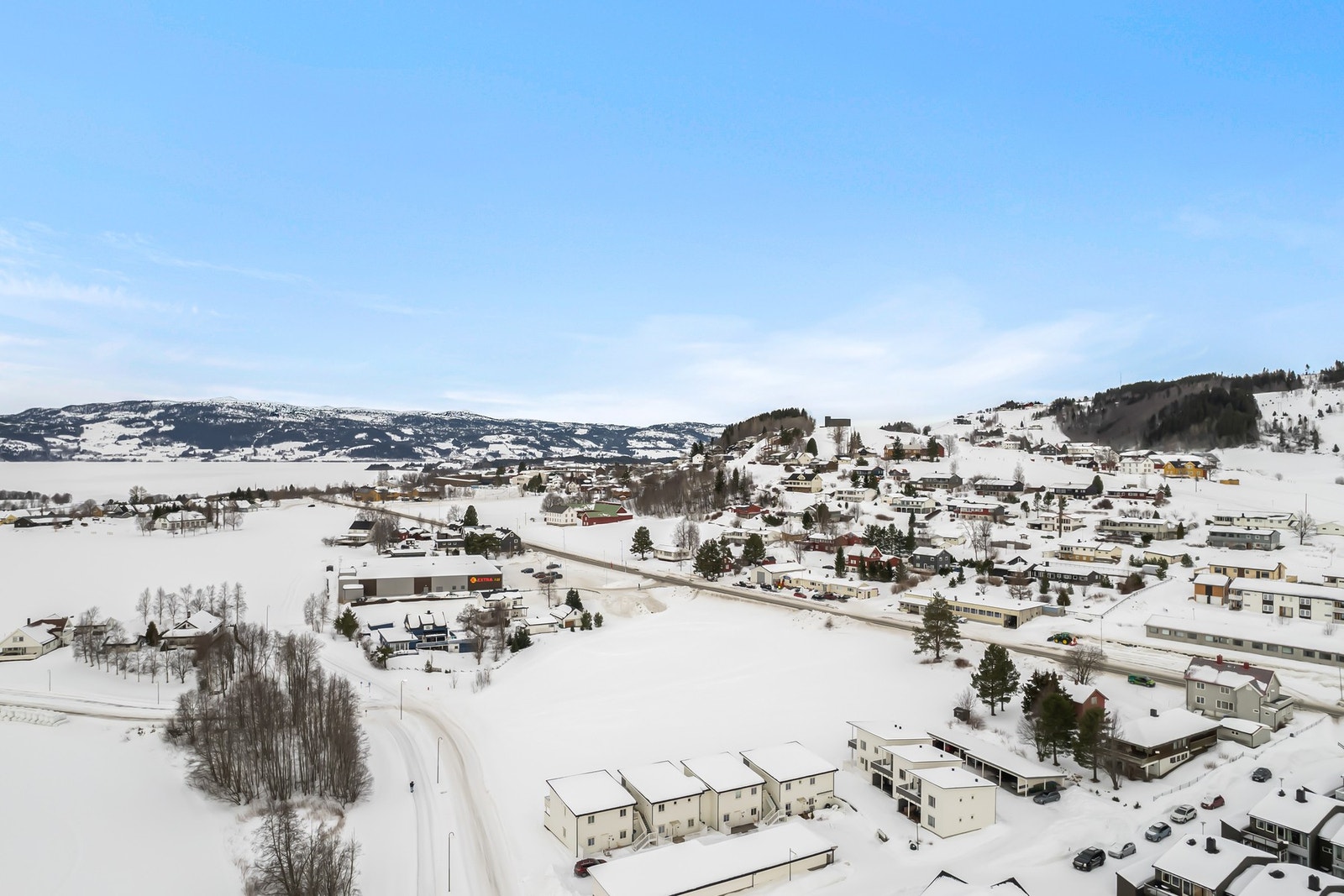 Fra tomta er det umiddelbar nærhet til nye Extra og Europris, samt gangavstand til blant annet kafeer, restauranter, bakeri, bank, lege, tannlege, vinmonopol, sykehjem, apotek, skoler og barnehage m.m. Galleribilde