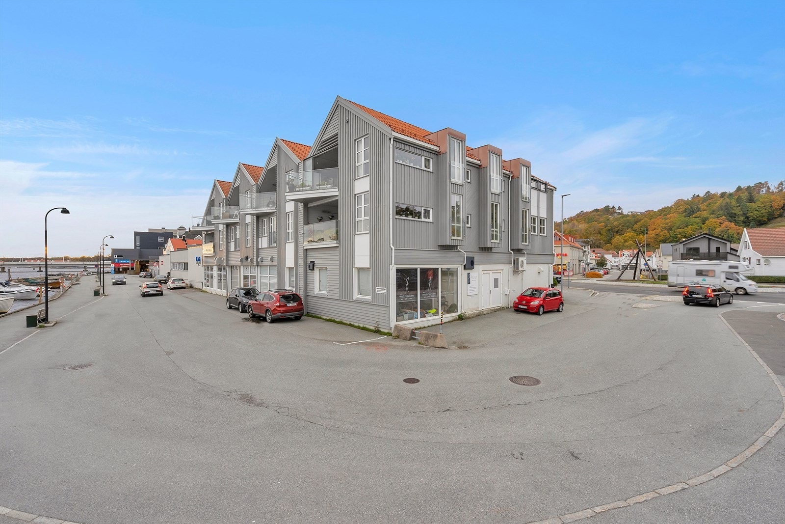 Eiendomsgrensen går i den hvite muren på siden. Seksjonen har benyttet parkeringsarealet her, men det gjøres kjøper oppmerksom på at arealet ikke medfølger eiendommen. Galleribilde