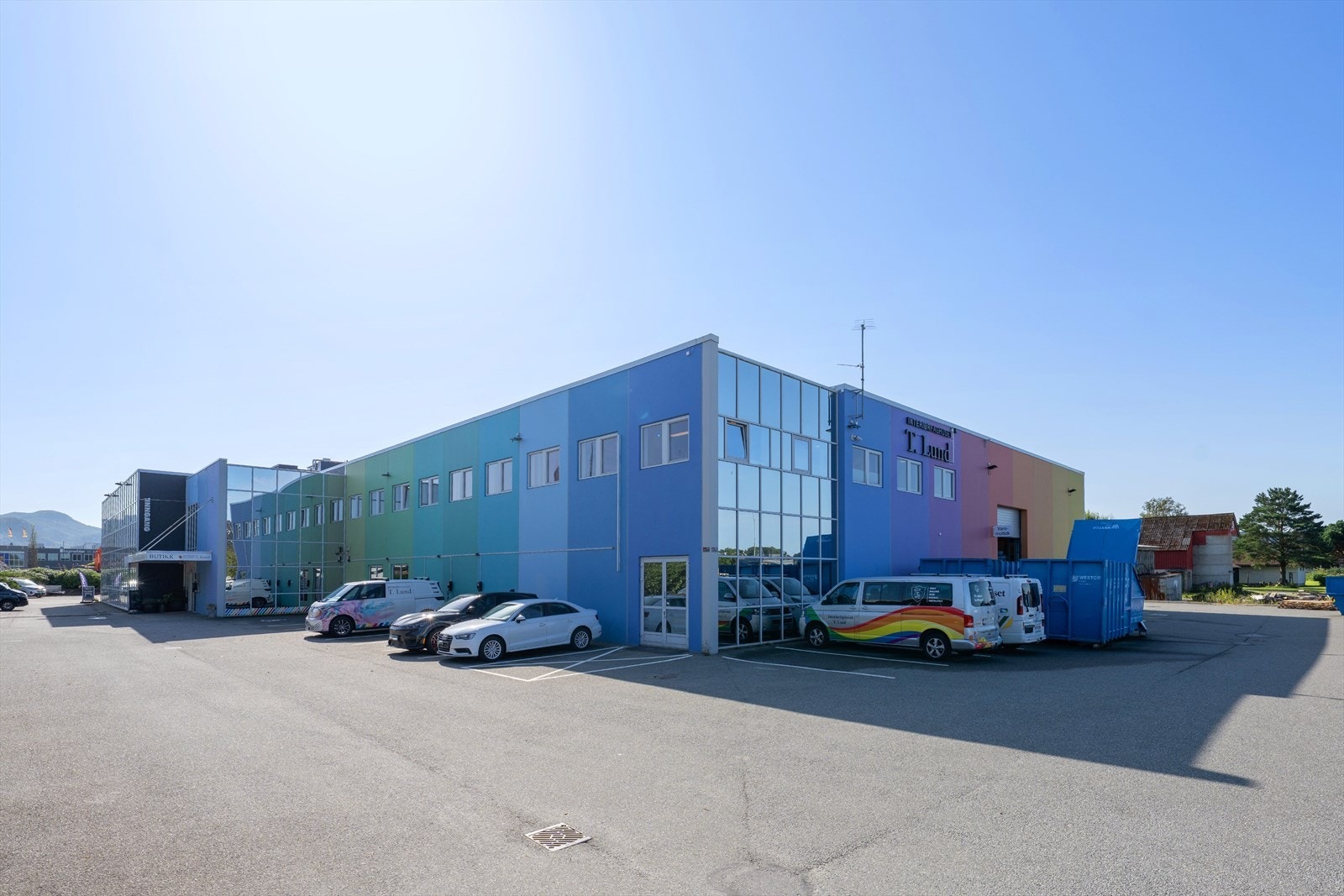 Fargerik næringseiendom med moderne fasade, strategisk plassert i et attraktivt område med gode parkeringsmuligheter og enkel adkomst. Galleribilde