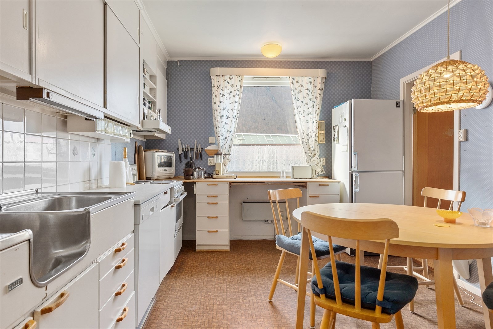 Romsleg kjøkken med god skåp- og benkeplass. Galleribilde