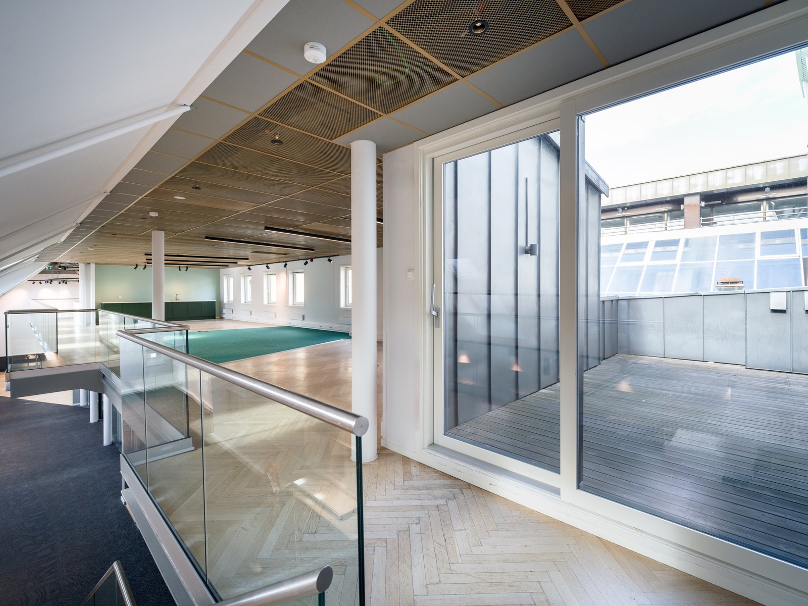 Mezzanin med åpne arbeidsplasser og utgang til privat takterrasse Galleribilde