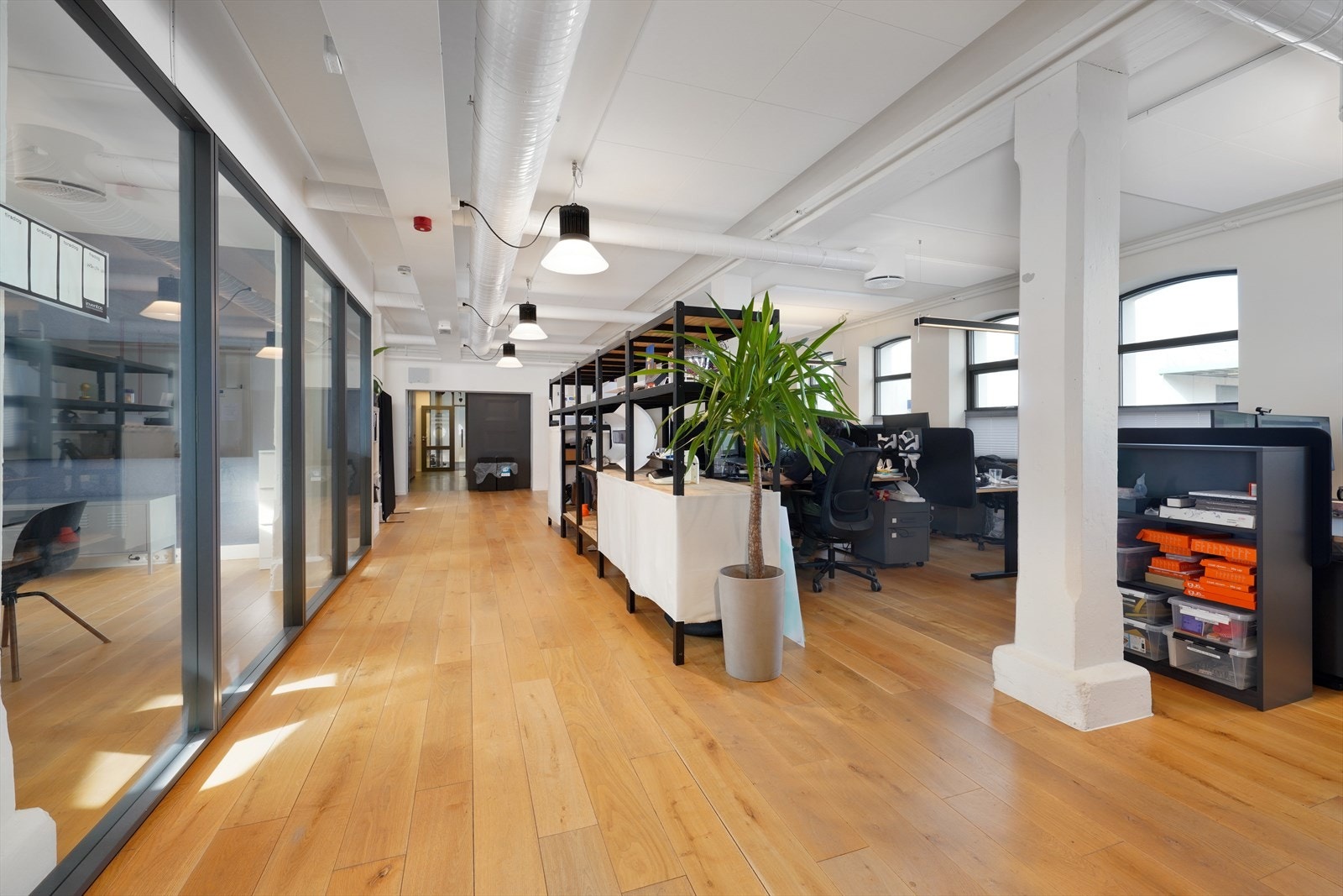 Moderne kontorlokale med lyse tregulv og store vinduer. Åpen planløsning gir en romslig og innbydende atmosfære. Galleribilde