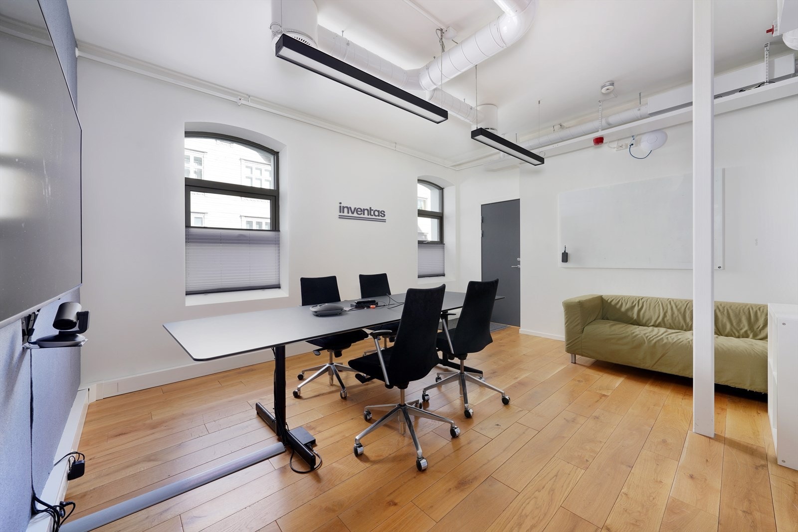 Lyst og moderne rom med store vinduer og god takhøyde, ideelt for kreative møter og arbeidsøkter. Galleribilde