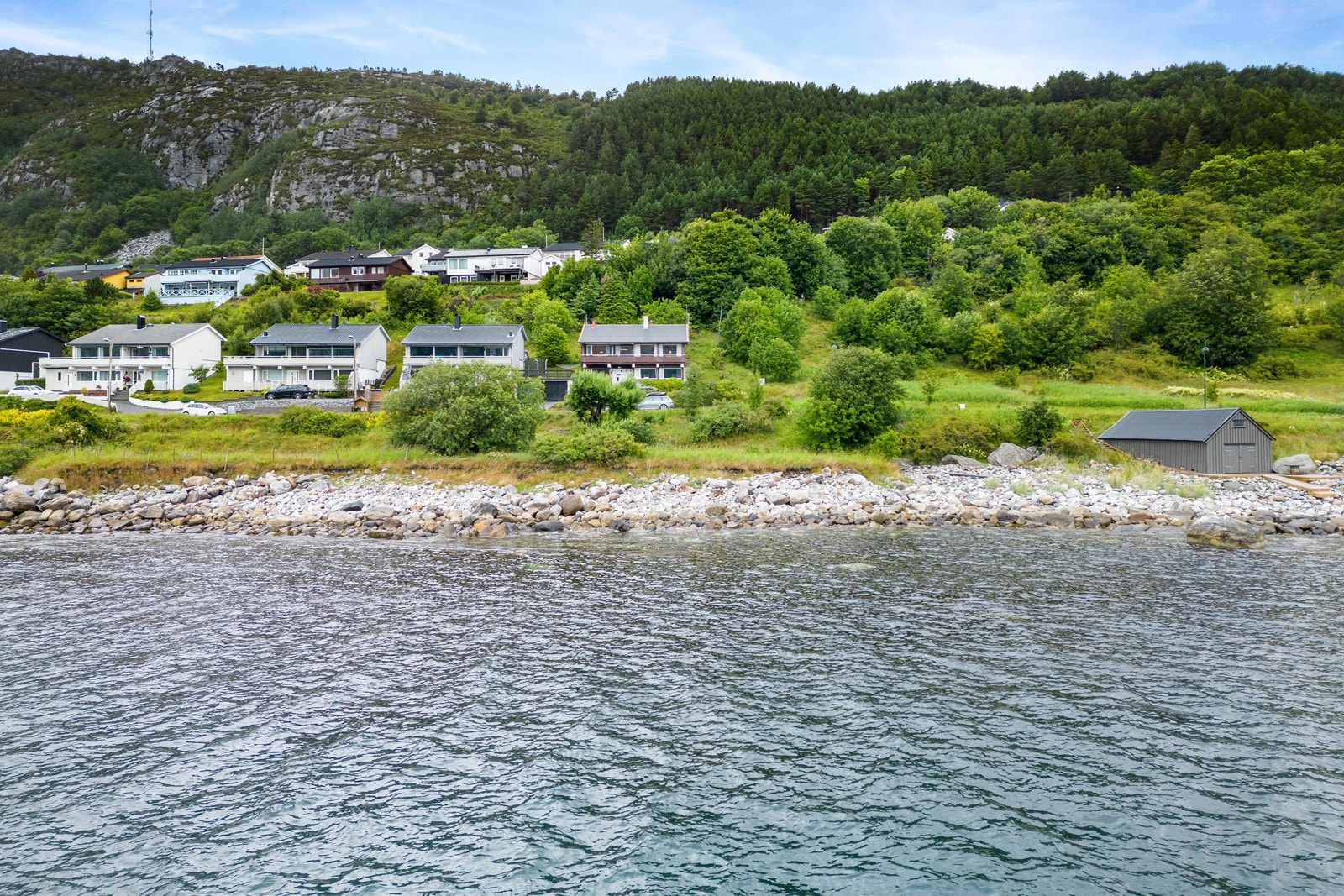 Tomten ligger idyllisk til i en naustrekke med flere tomter på sørsiden av Hessa. Galleribilde