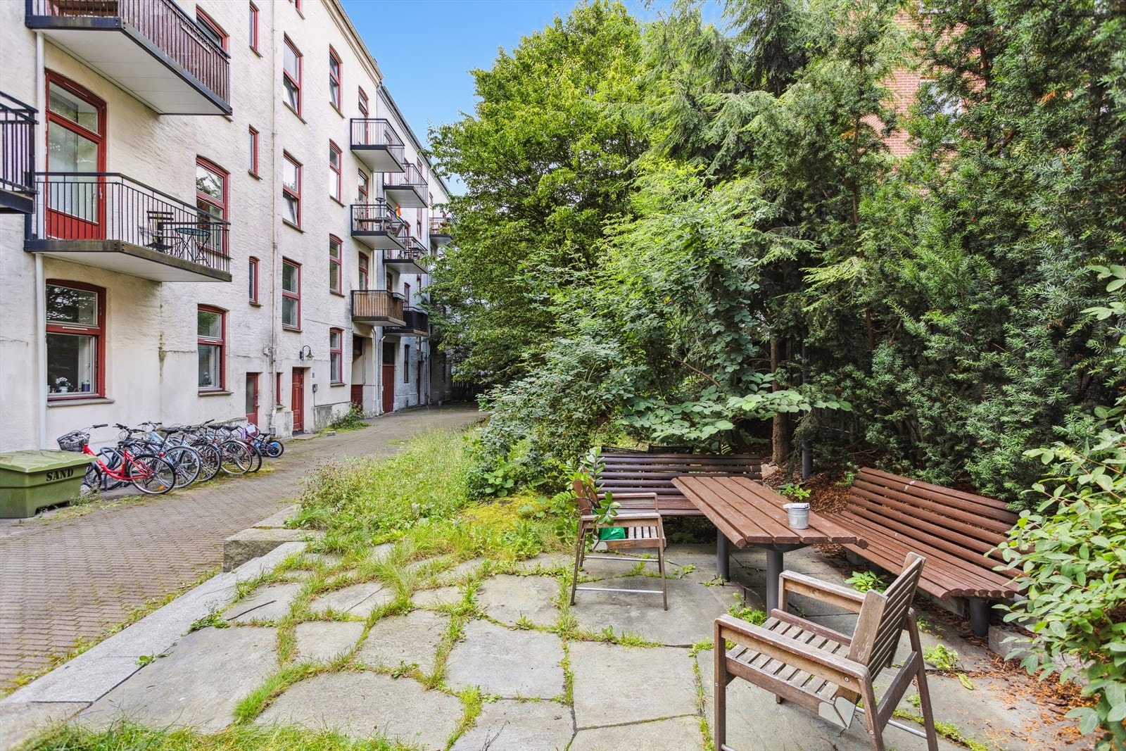 Sameiet har felles baggård med nabogården. Pent opparbeidet med beplantning, trær og sittegrupper. Det er også sykkelparkering i bakgården. Galleribilde