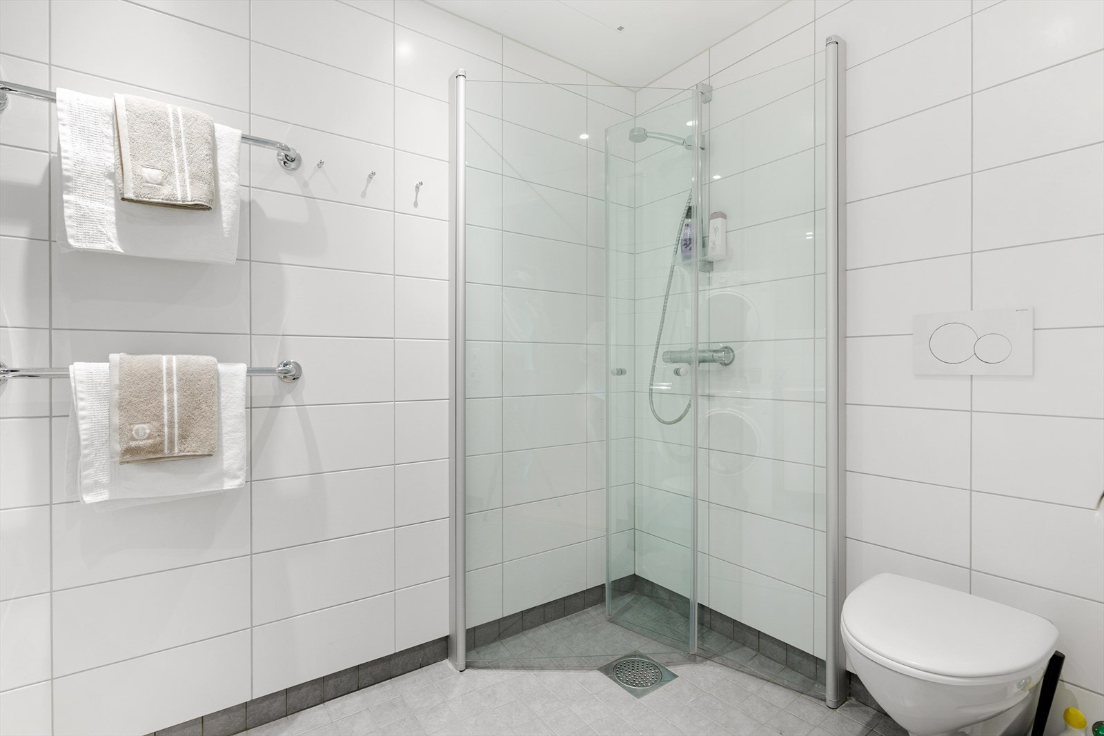 Badet inneholder veggmonterte dusjdører, servant på med underskap, speilskap med lys over, opplegg for vaskemaskin og veggmontert wc. Dette er et herlig sted å starte dagen. Galleribilde