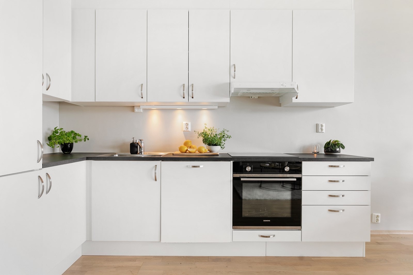 Innredning har hvite fronter og laminat benkeplate. Det er godt med oppbevaringsplass i skuffer og skap som gjør det enkelt å holde orden. Galleribilde