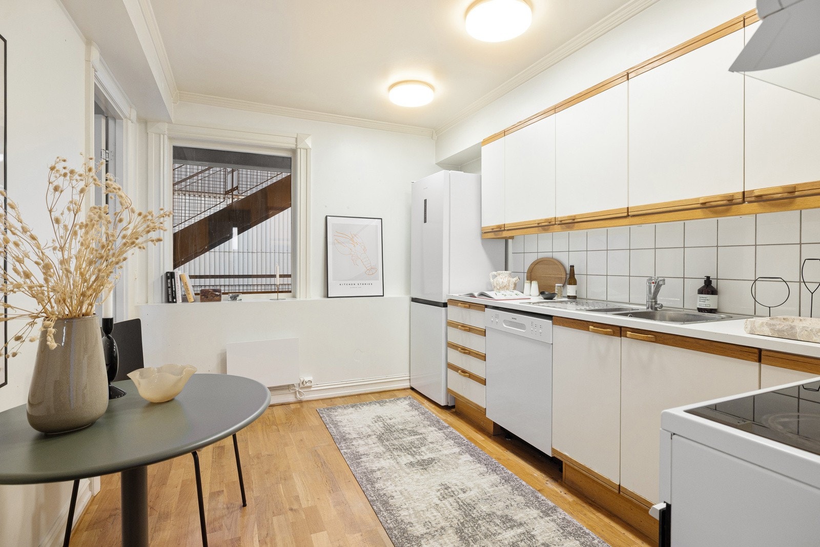 Kjøkkeninnredning fra 2002 med glatte hvite fronter med eikelist, 28mm tykk og hvit laminatbenkeplate med nedfelt 1,5 vaskekum i børstet stål og ettgreps blandebatteri i rustfritt stål fra Mora. Galleribilde