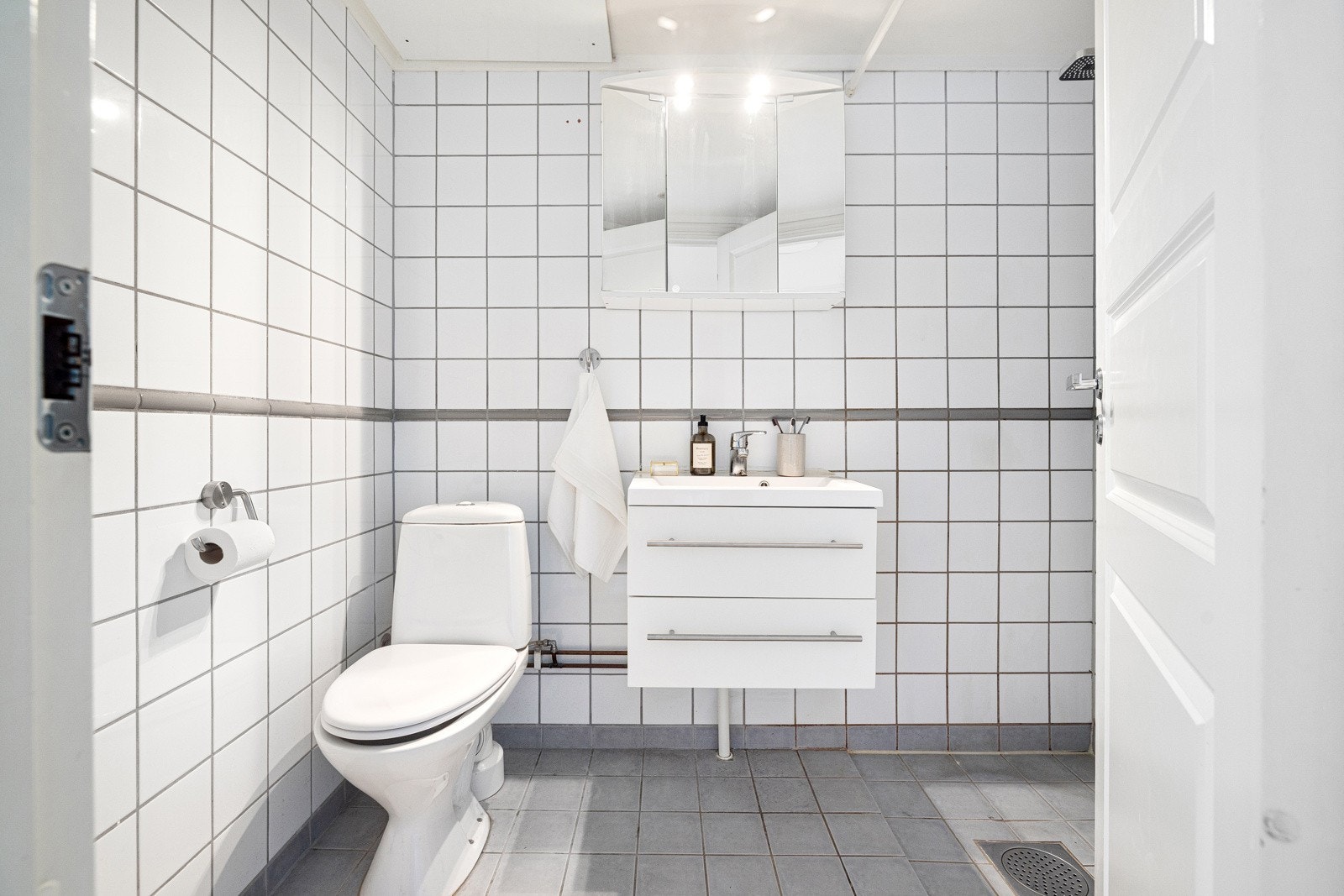 Badet er innredet med servantskap med hvite skuffefronter med servant i kompositt med ettgreps blandebatteri i rustfritt stål fra Oras. Galleribilde