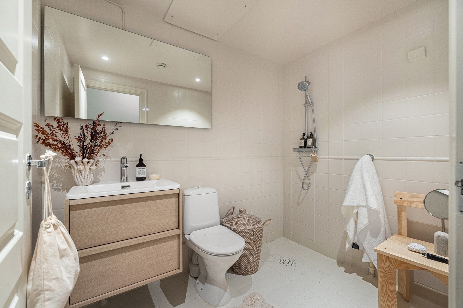 Inspirasjonbilde fra en naboleilighet hvor badet er oppgradert med ny servantinnredning, fugene er malt med fugemaling, speil og nymalte veggfliser. Galleribilde