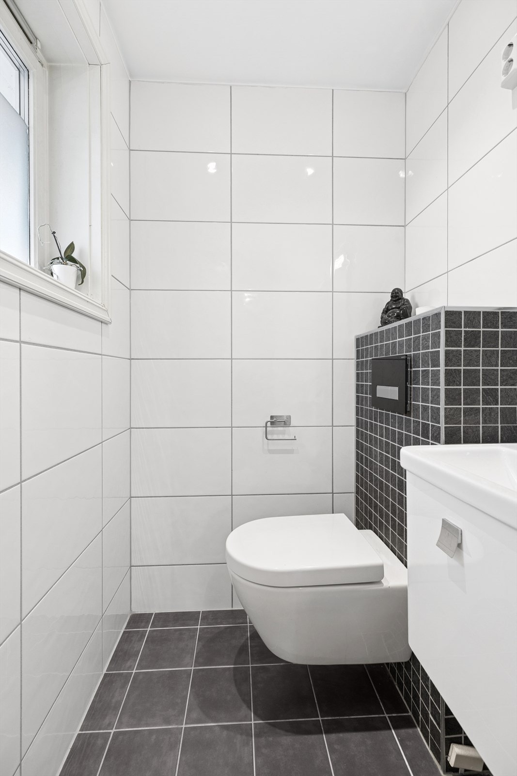 Toalettrommet fremstår moderne og funksjonelt, med flislagte gulv og elektriske varmekabler som gir god komfort. Tilgang fra gangen. Galleribilde