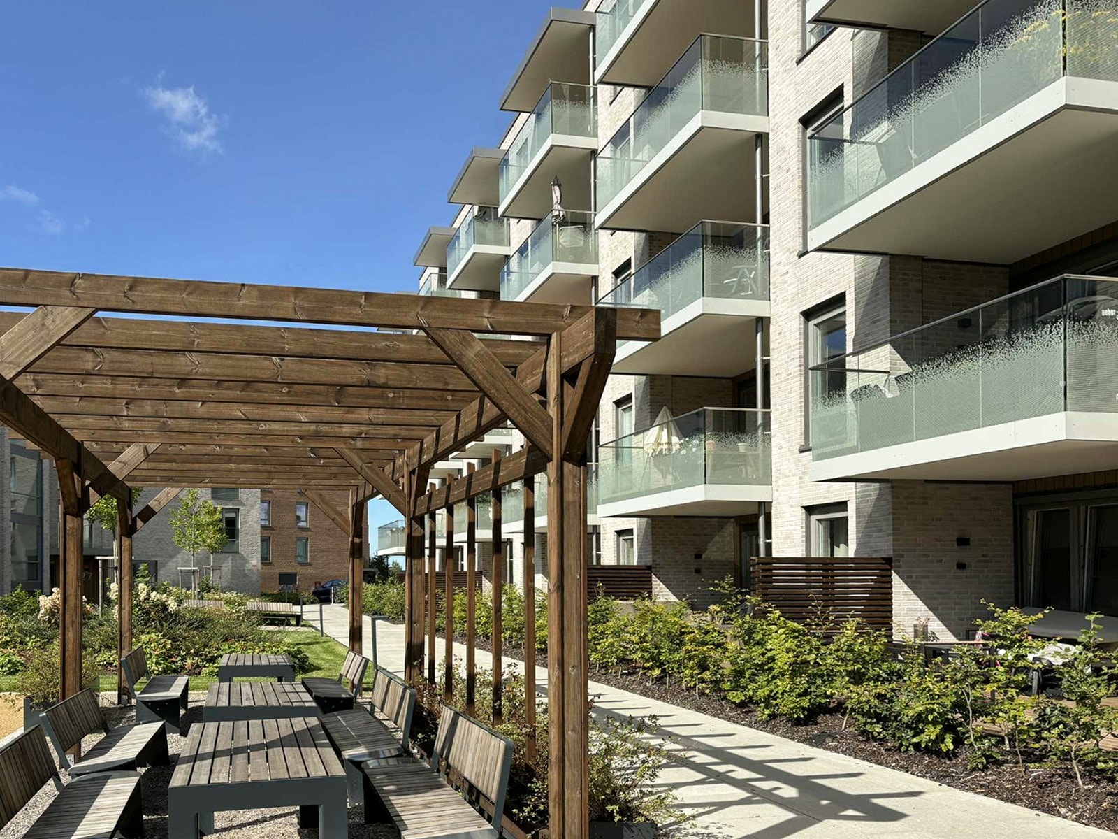 Flott uteområde med pergola og flere sittegrupper. Galleribilde