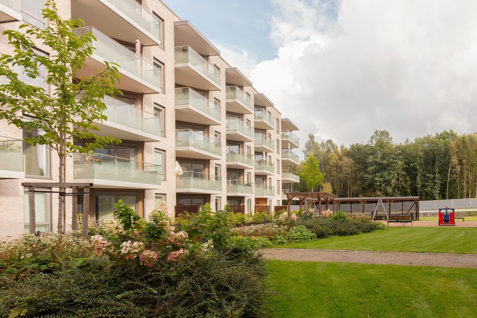 Hyggelige og barnevennlige fellesarealer med plen og lekeapparater. Galleribilde