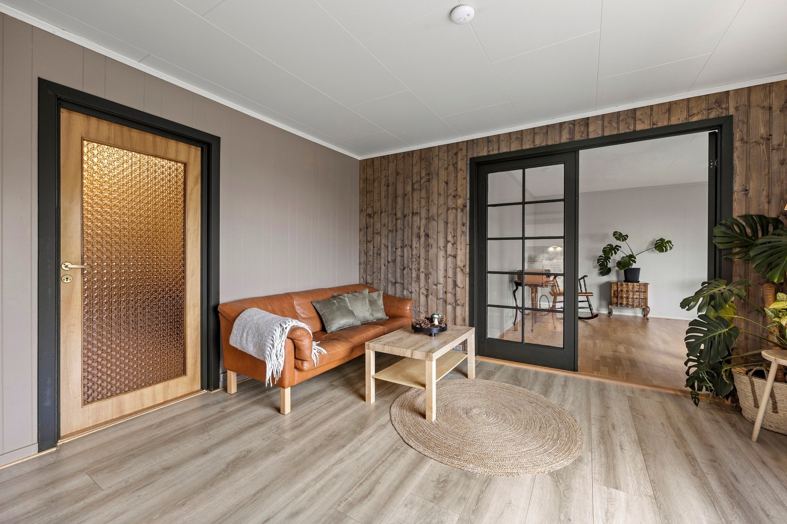 Dobbel glassdør skiller de to stuene og er en pen detalj i rommet Galleribilde