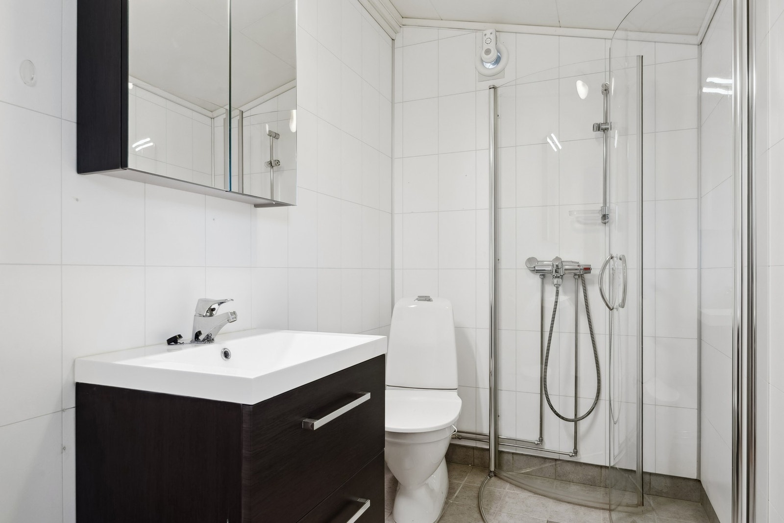 Baderommet i 1. etasje ble oppgradert i 2008 og har flislagt gulv, baderomsplater på vegger, servantinnredning, dusjhjørne med dører og toalett. Galleribilde