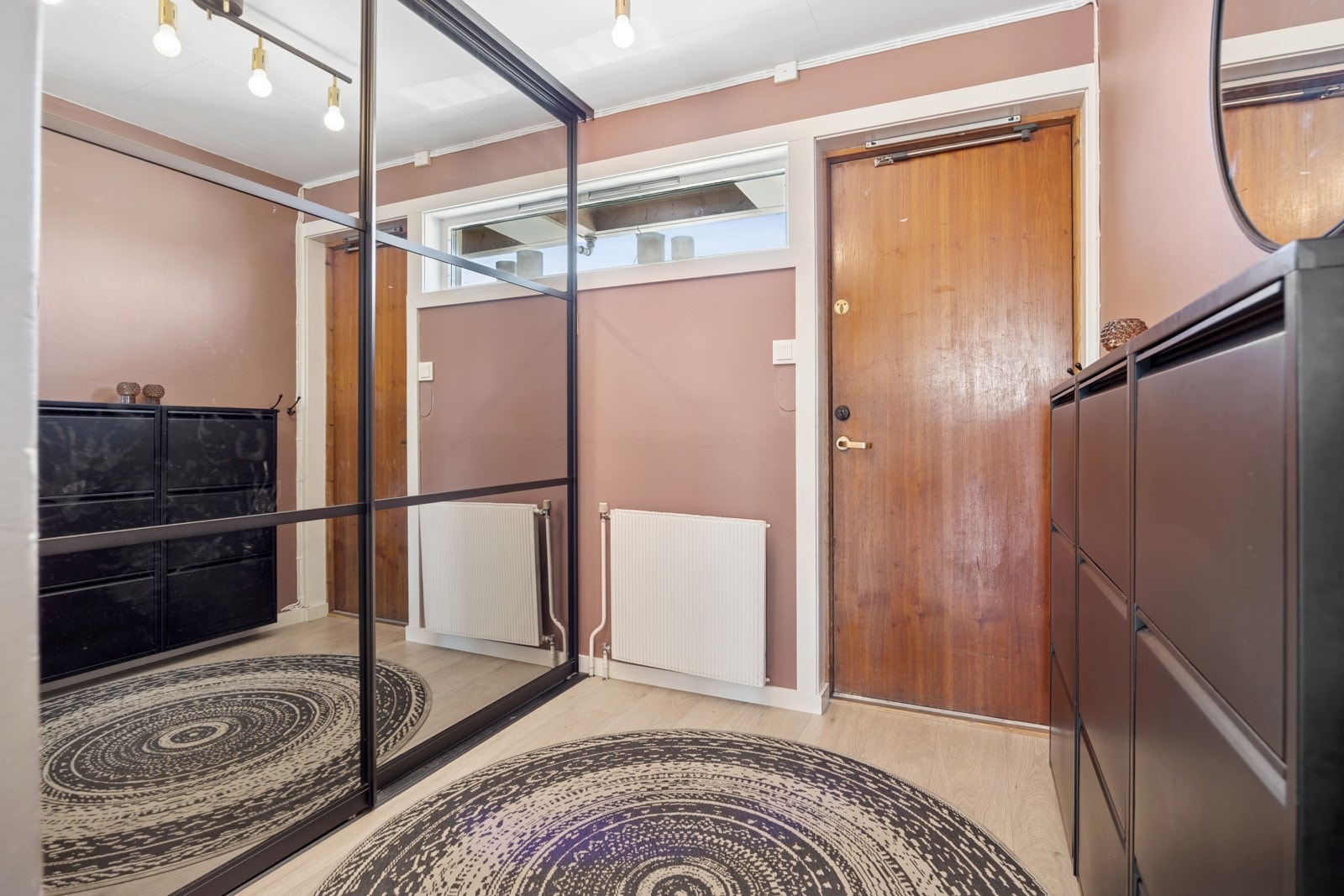 Innenfor døra blir du møtt av en romslig entré med gode oppbevaringsmuligheter i skyvedørsgarderobe. Vegg i vegg er det adkomst til et praktisk vaskerom. Galleribilde