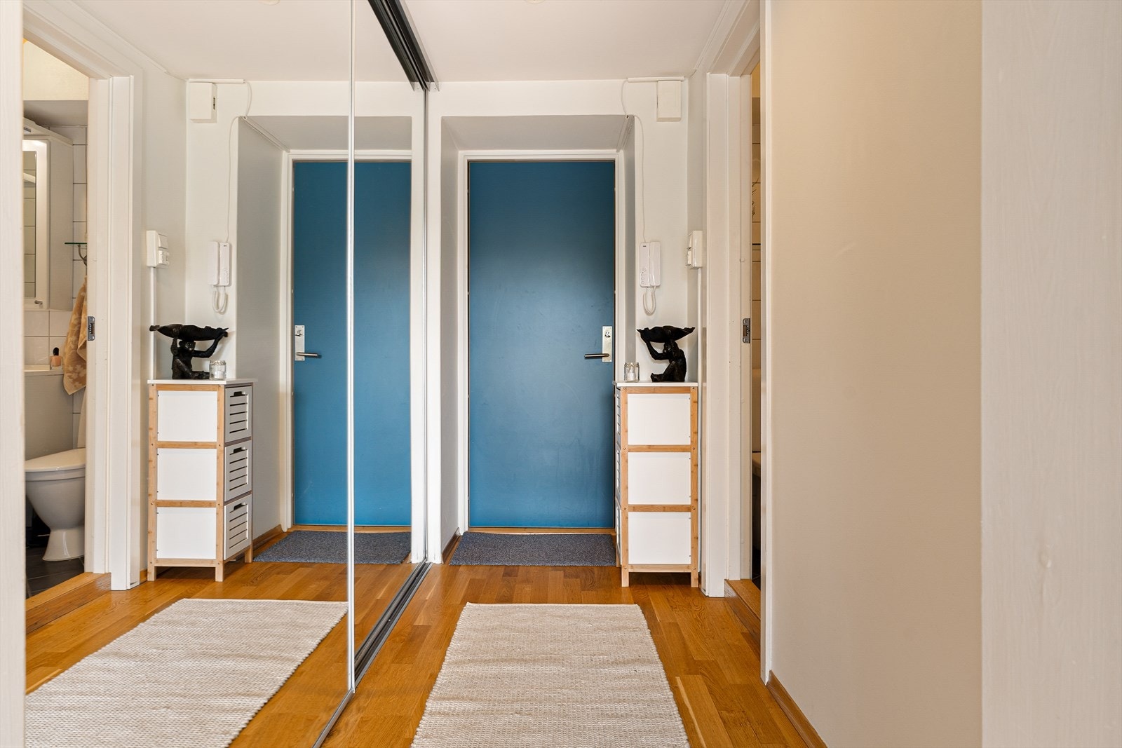 Her blir man ønsket velkommen inn til leilighetens entrè på ca. 2,5 m². Gangen har integrert skyvedørsgarderobe for oppbevaringsplass og klesheng. Galleribilde
