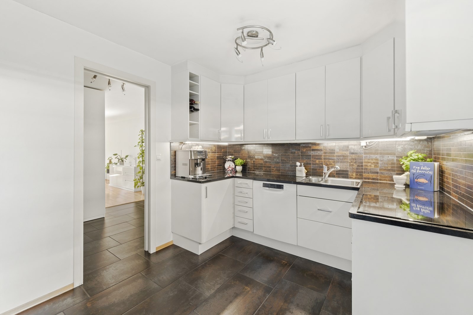 Kjøkkeninnredning med glatte fronter og benkeplate i stein (Black Galaxy) med nedfelt vask. Galleribilde