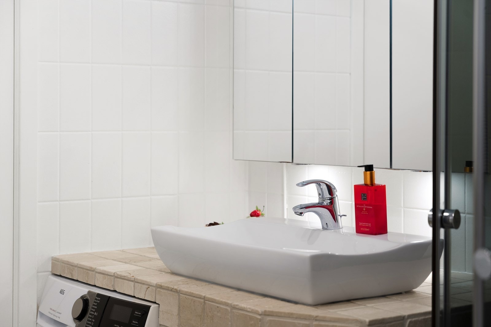 Badet er innredet med vegghengt toalett, servant på innredning, speilskap og dusjkabinett. Galleribilde