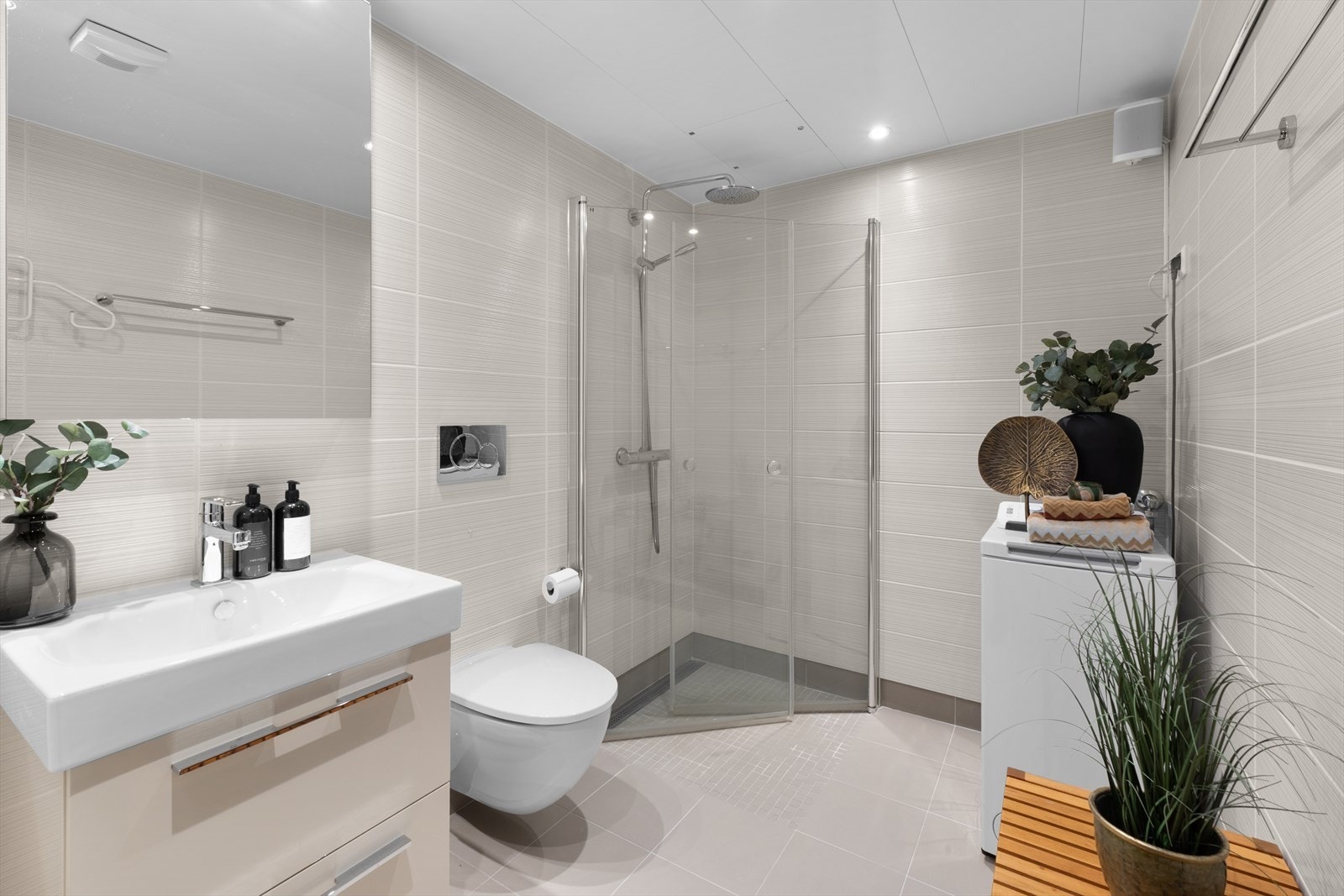 Delikat og innbydende bad med gulvvarme, downlights, vegghengt klosett og servant med underskap Galleribilde