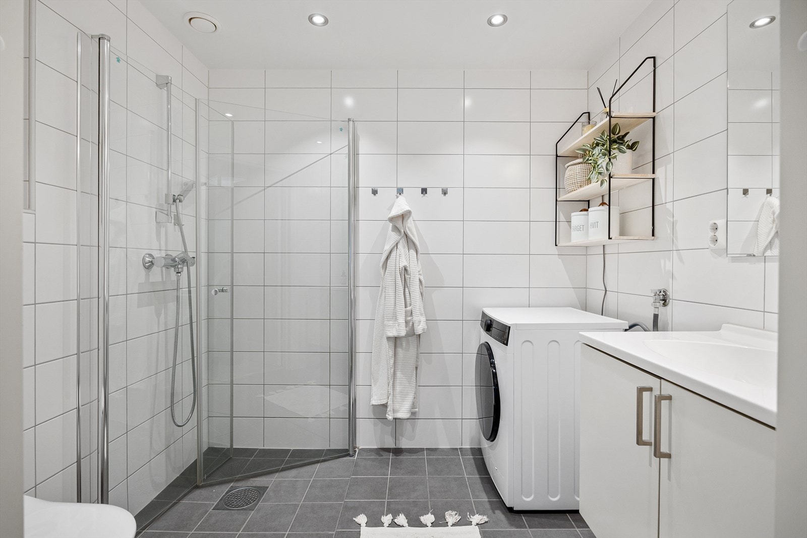 Tilknyttet hovedsoverommet er det ett bad med opplegg for vaskemaskin. Det har også et moderne dusjhjørne med glassdører, veggheng toalett og servant med underskap. Galleribilde