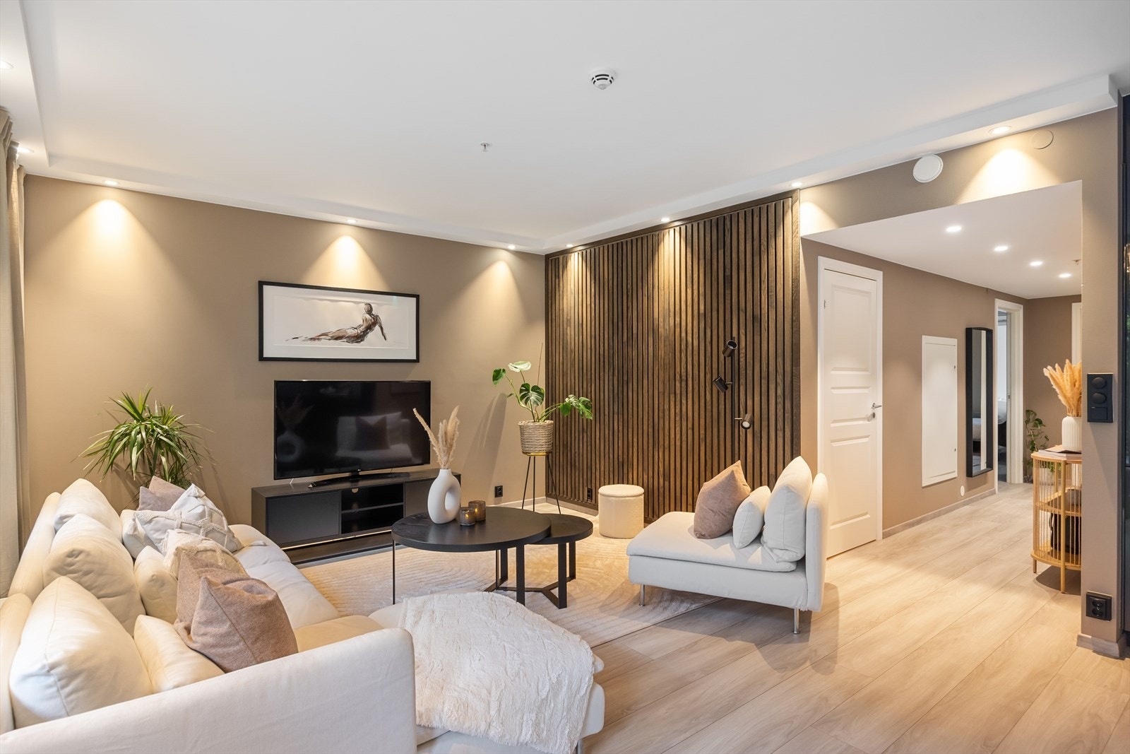 Gjennom hele leiligheten er det spotter i taket. I kjøkken og stue er det downlights langs veggene som rammer inn rommet og skaper en elegant atmosfære, samtidig som de gir et behagelig og jevnt lys. Galleribilde