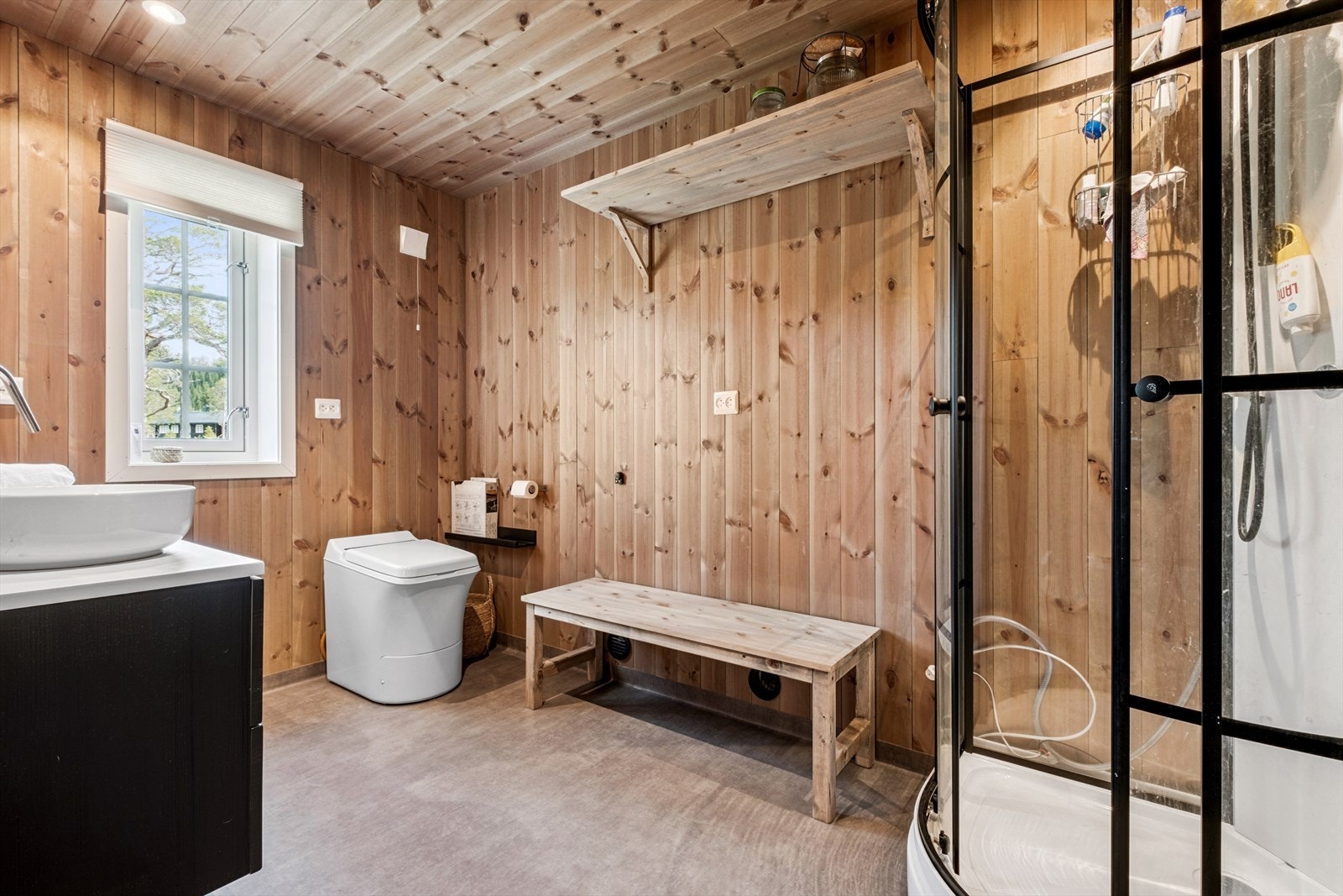 Flott baderom med Cinderella forbrenningstoalett, dusjkabinett og vask. Dieselvarmer med tilluft under benk. Galleribilde