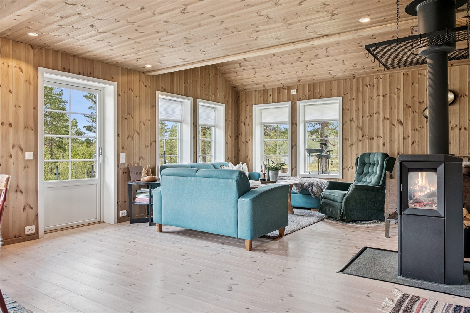 Fra spisestue mot stue. Solid og kraftig vedovn. Utgang til uteplass. Galleribilde