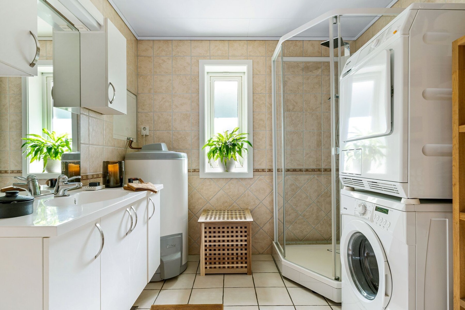 Lyst og pent flislagt bad utstyrt med varme i gulv, opplegg for vaskemaskin, dusjkabinett, innredning med servant og mye skapplass. Galleribilde