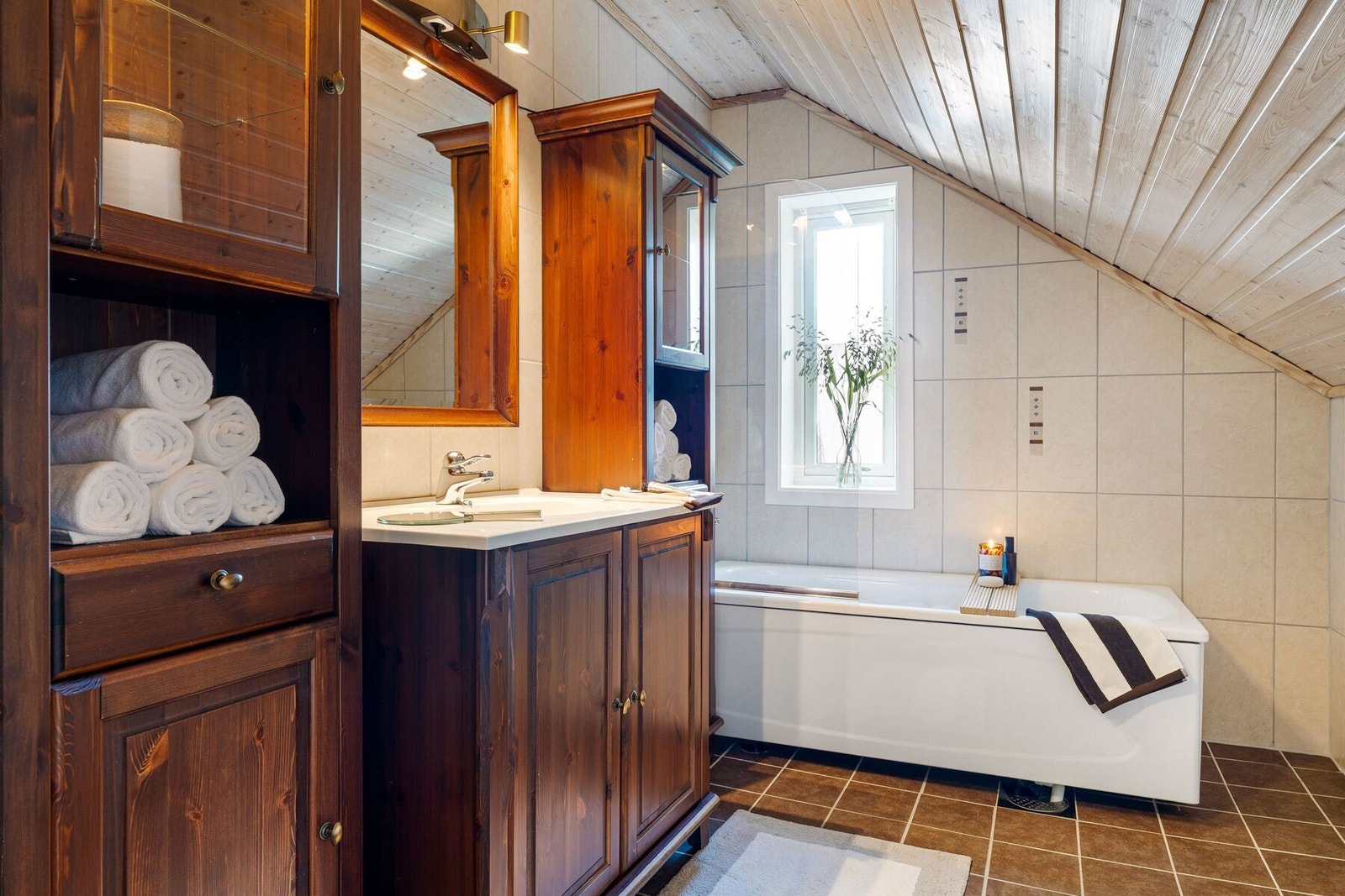 Badet er utstyrt med badekar som gir en deilig spafølelse, dusjkabinett, toalett og servant med generøs mengde skapplass til hygieneartikler og håndklær. Galleribilde