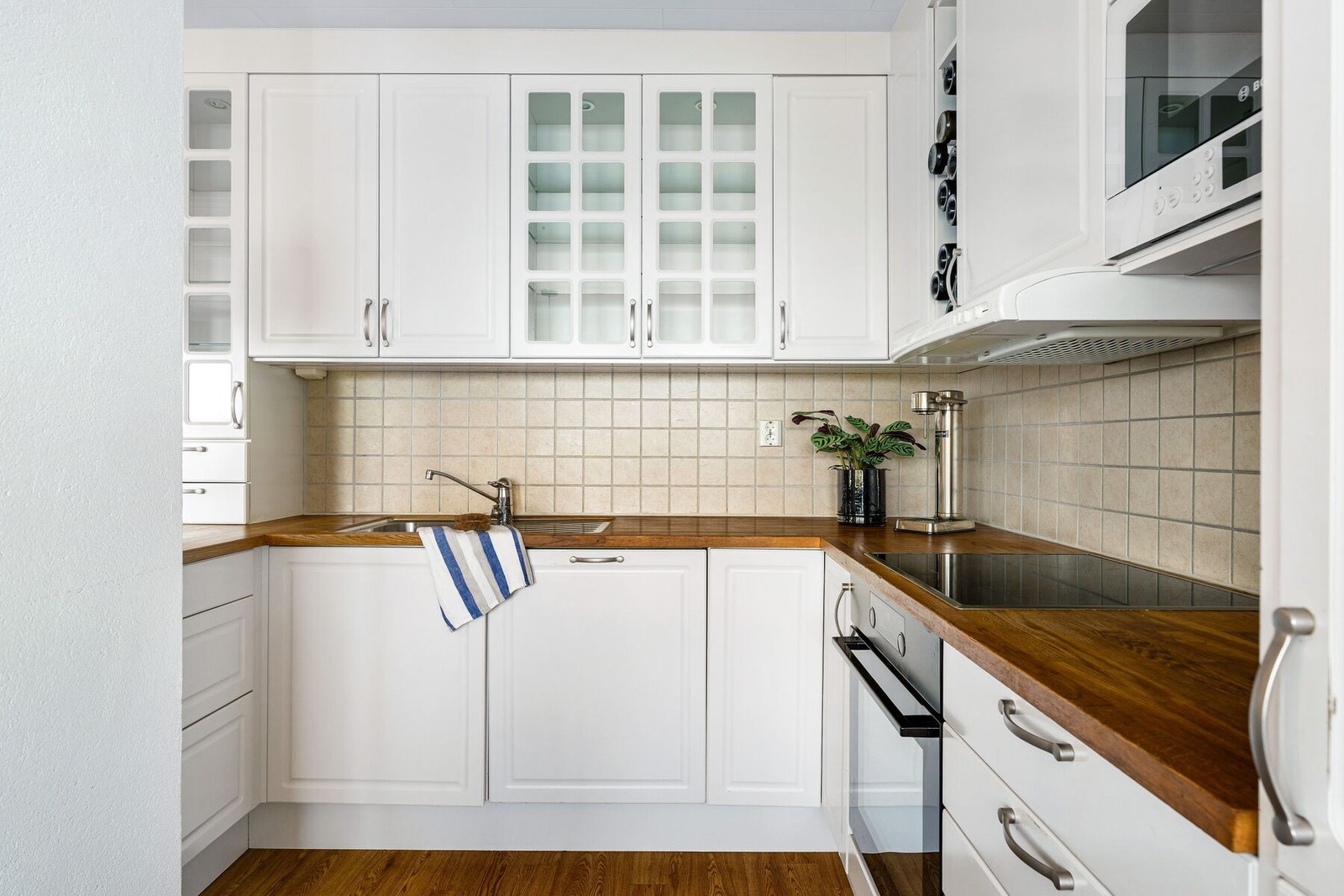 Stilrent, lyst og klassisk kjøkken med profilerte fronter og heltre benkeplate. Flis over benk som sørger for lettvint rengjøring. Galleribilde