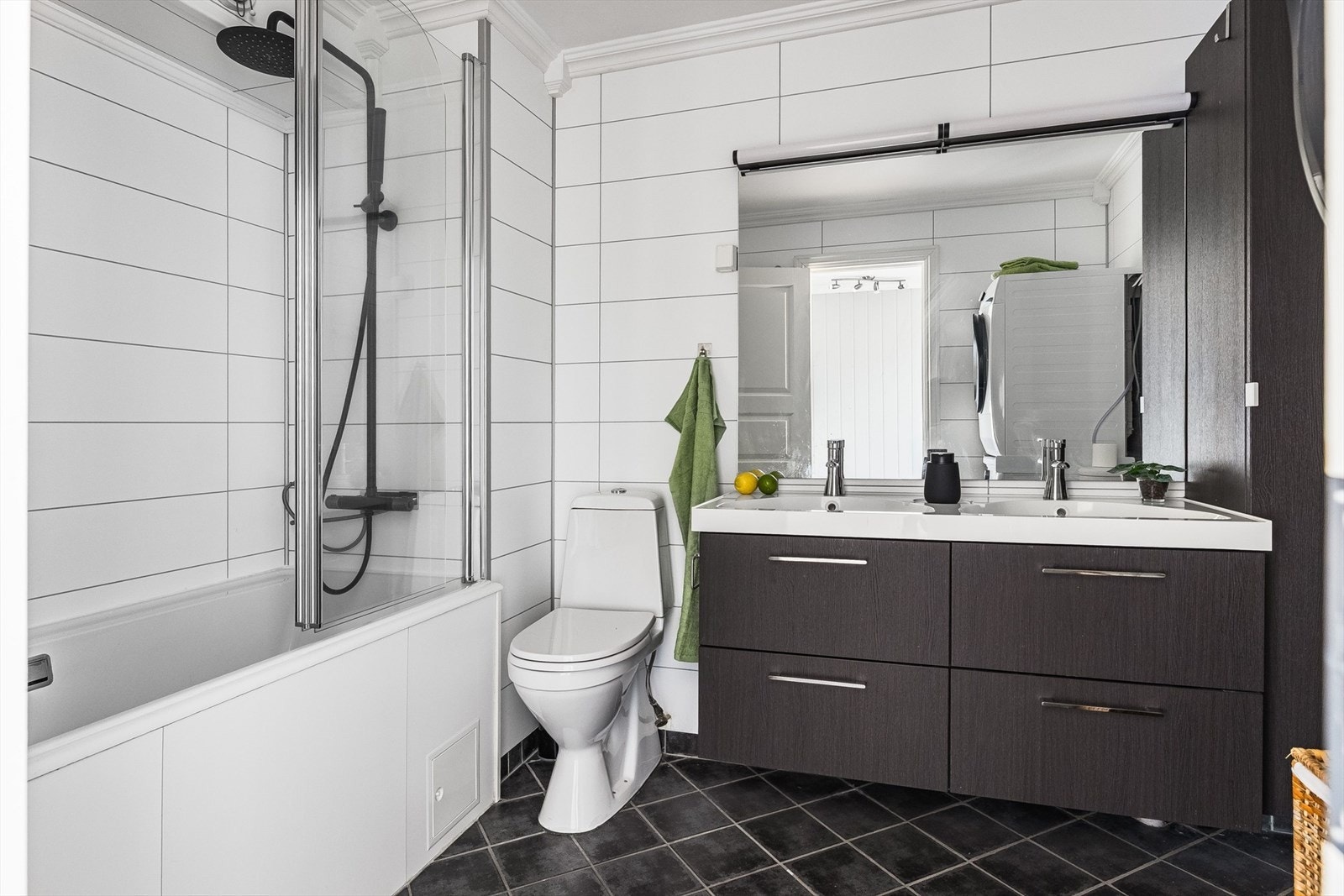 Flott baderomsinnredning med skuffer og heldekkende dobbel servant, stort speil med belysning over, samt ekstra høyskap ved siden av. Baderommet er også utstyrt med badekar fra 2021 med glassvegg og både hånd- regnfallsdusj, samt gulvstående toalett. Galleribilde