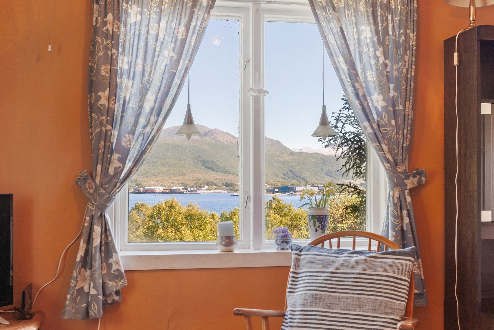 Fra stuen og kjøkkenet har man flott utsikt til sjø og fjellene i nærområde Galleribilde