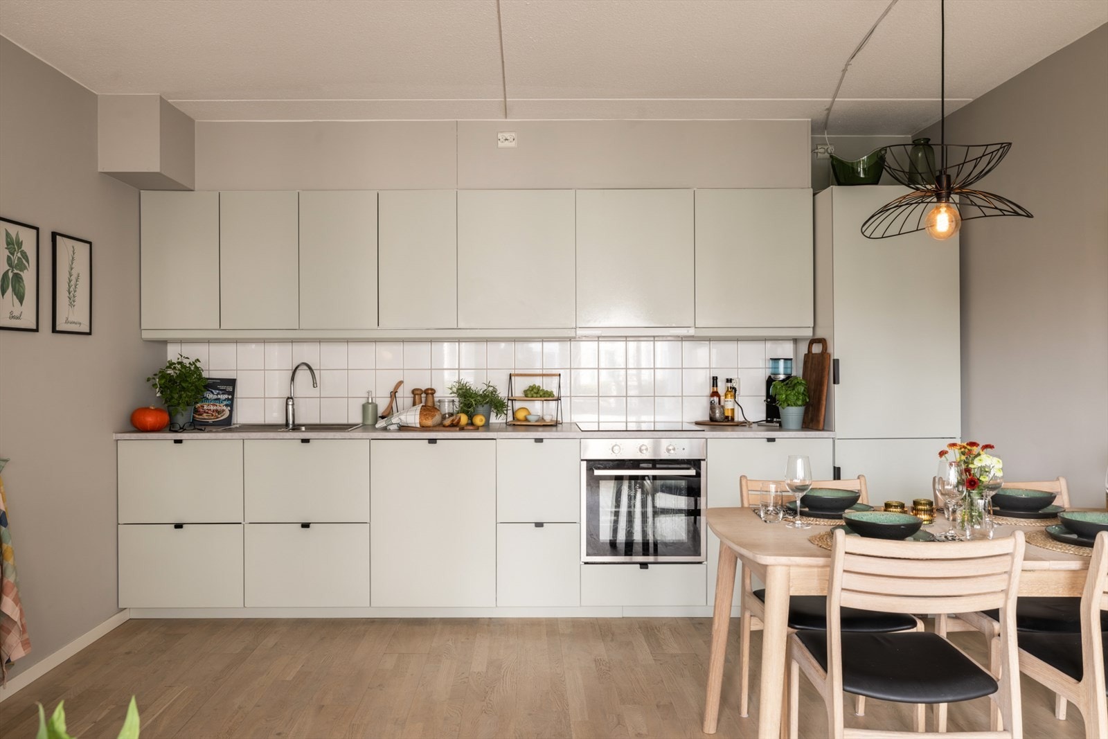 Kjøkkeninnredning med slette fronter, nedfelt oppvaskkum med 1-greps blandebatteri og integrerte hvitevarer. Galleribilde