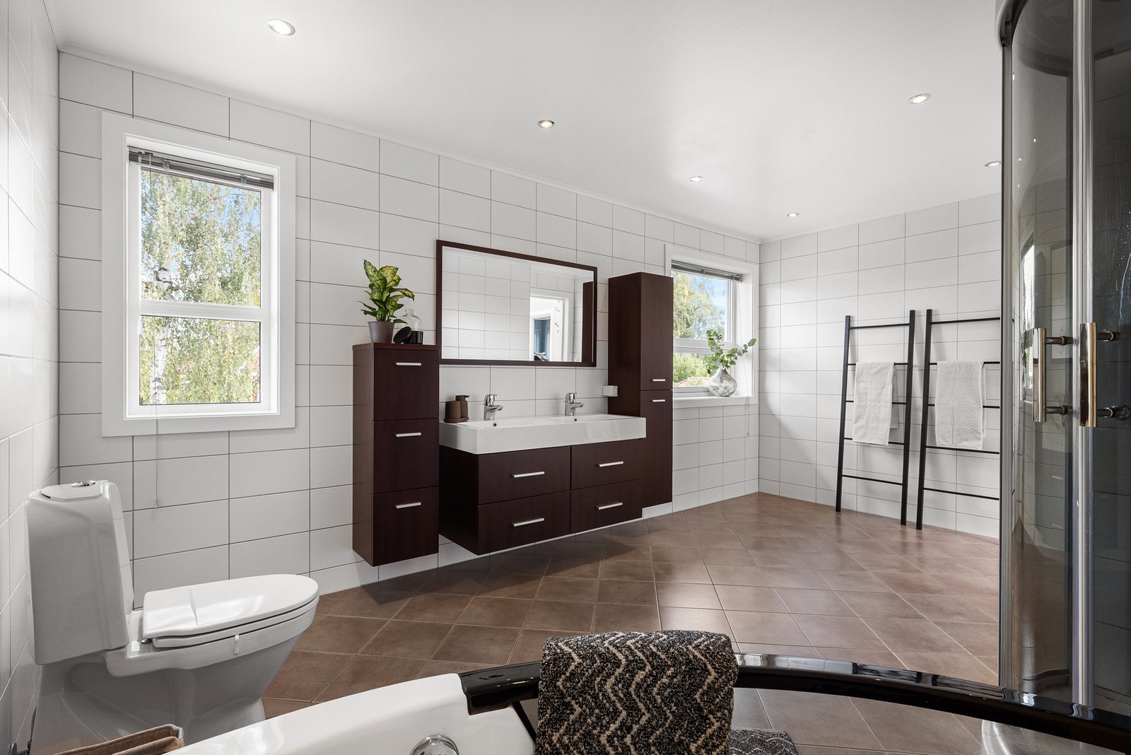 Et romslig og pent, flislagt bad med gulvvarme Galleribilde