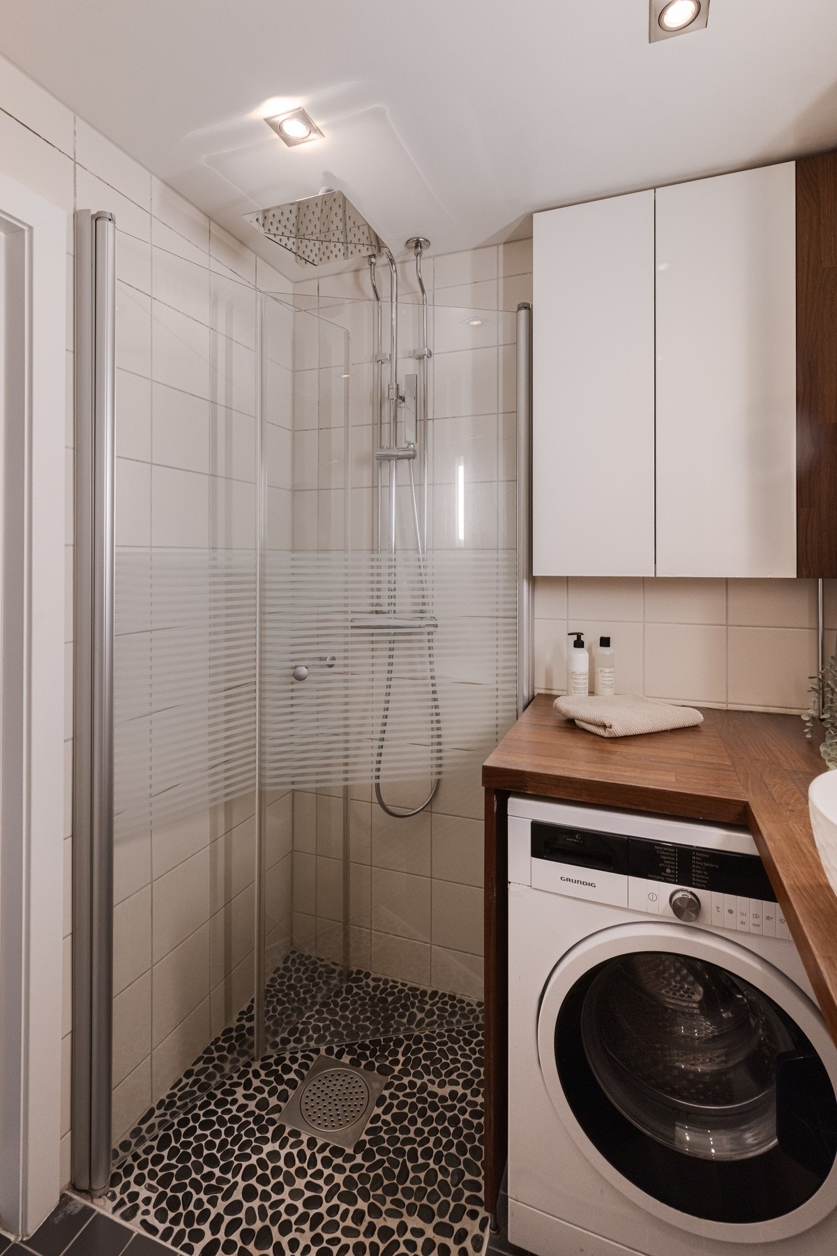 Her finner du hjørnedusj med innfellbare glassdører og rullesteinsfliser i dusjsonen. Galleribilde