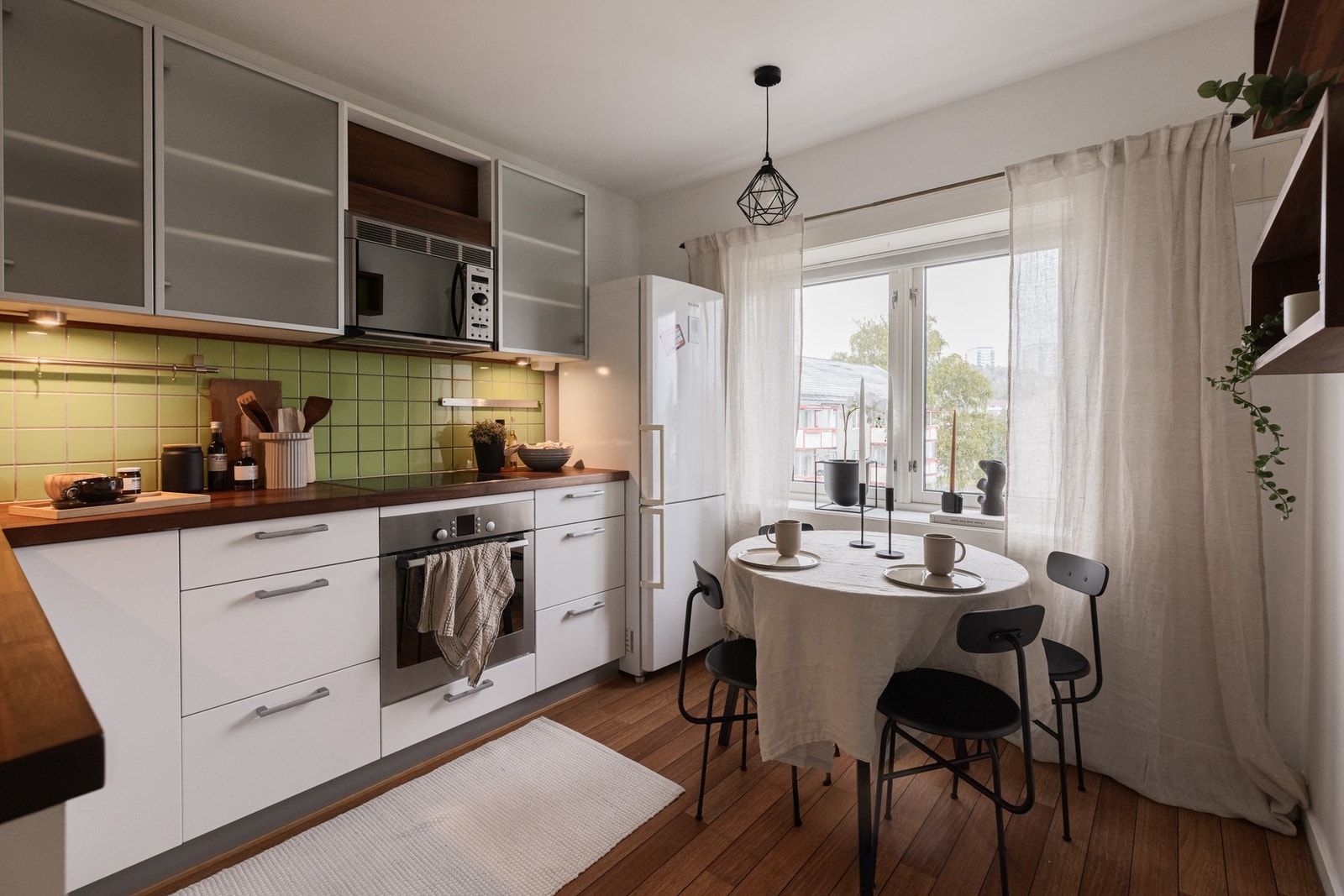 Det separate kjøkkenet fra 2007 er både funksjonelt og tiltalende. Innredningen er hvit og tidløs, med glatte fronter og enkelte overskap med frostet glass. Galleribilde