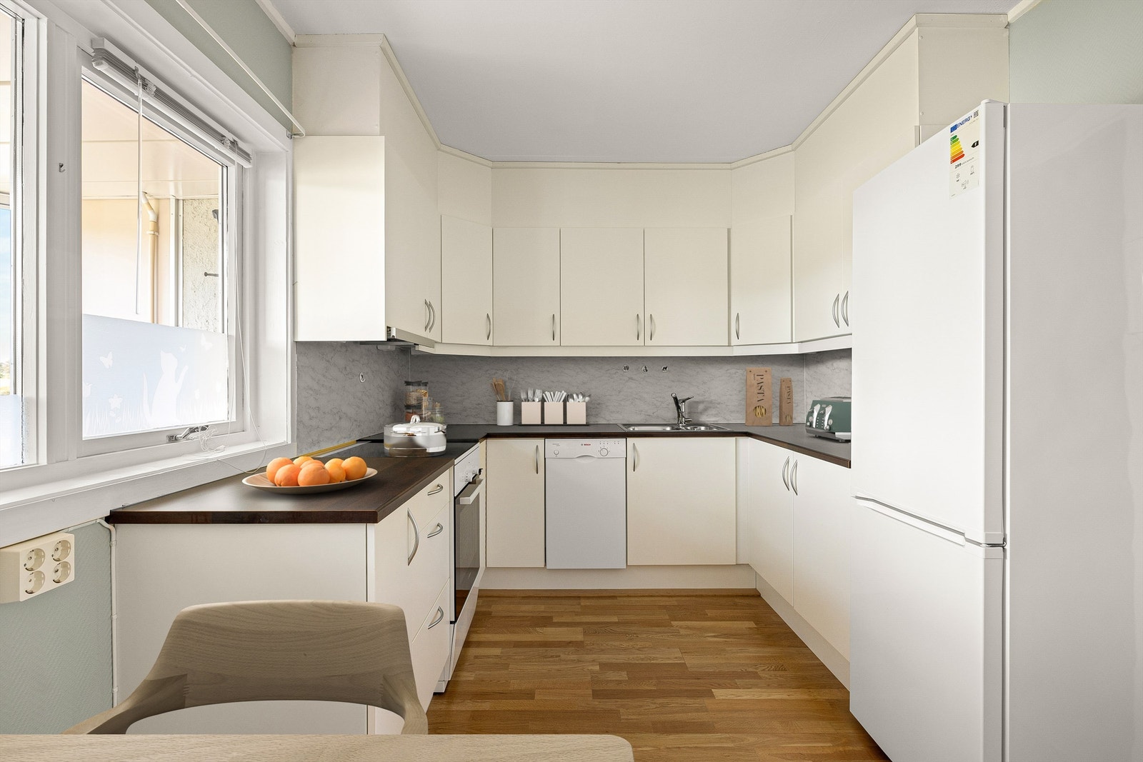 Kjøkkeninnredningen er en velholdt løsning fra JKE som ble installert i 2011 og bærer preg av forsiktig bruk gjennom påfølgende år. Digitalt møblert bilde. Galleribilde