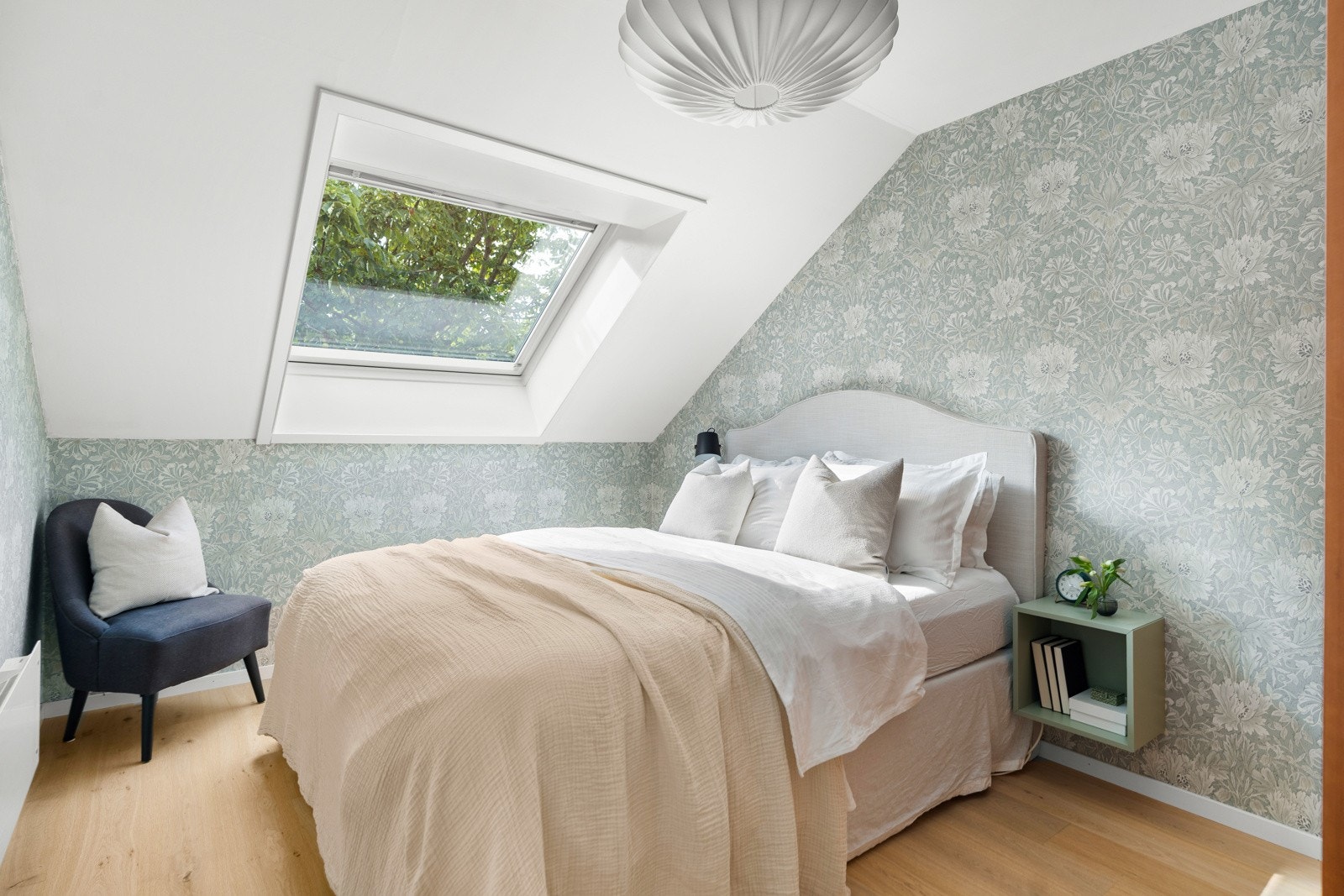 Vakkert og lyst soverom med plass til dobbeltseng, tilhørende nattbord og garderobeskap. Grønt og frodig utsyn fra takvindu på sommerstid, ingen innsyn Galleribilde