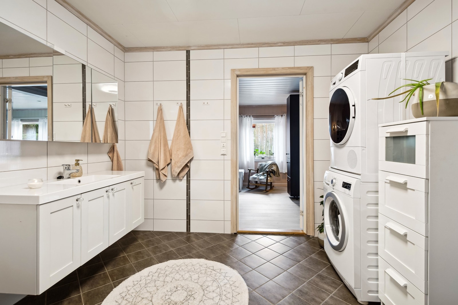 Badet er innredet med en romslig baderomsinnredning med heldekkende servant og speilskap. Galleribilde