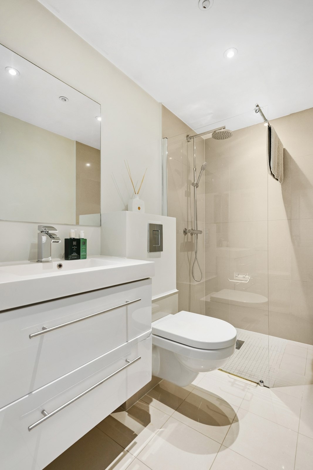 Delikat bad med stilren servantinnredning, vegghengt toalett og dusjhjørne. Galleribilde